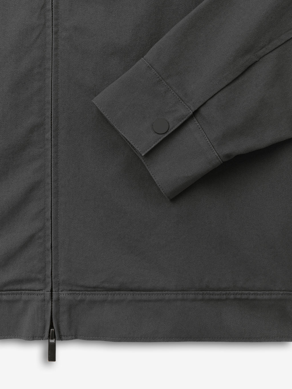 Cotton Twill Work Jacket in dark grey with a close-up of the sleeve featuring a snap button cuff and a visible zipper detail, highlighting durable, premium outerwear craftsmanship.