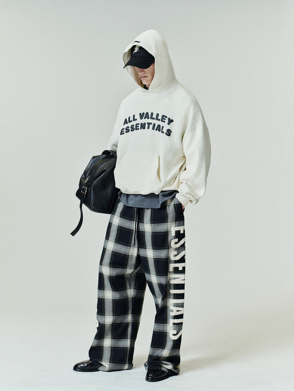 Flannel Lounge Pant in a vintage black and white plaid design with a wide-leg silhouette and prominent cream-colored vertical lettering along the side for a relaxed, stylish fit.