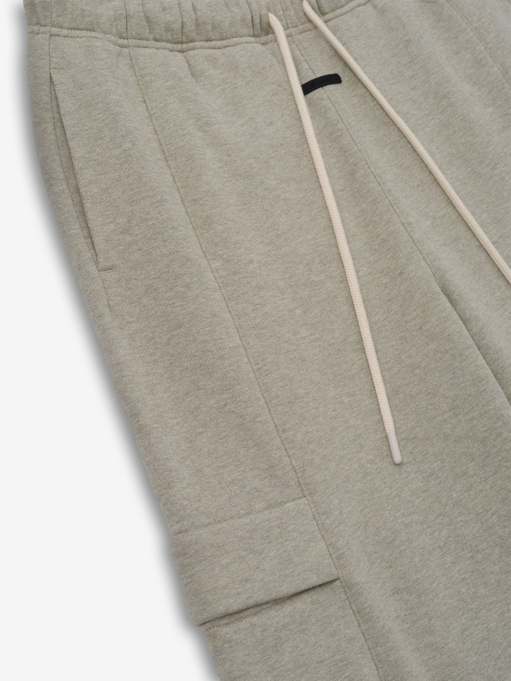 Womens Fleece Cargo Relaxed Sweatpant in a light heathered beige featuring soft fleece fabric, an elastic waistband with long drawstrings, side seam pockets, and a flap cargo pocket for relaxed bottoms.