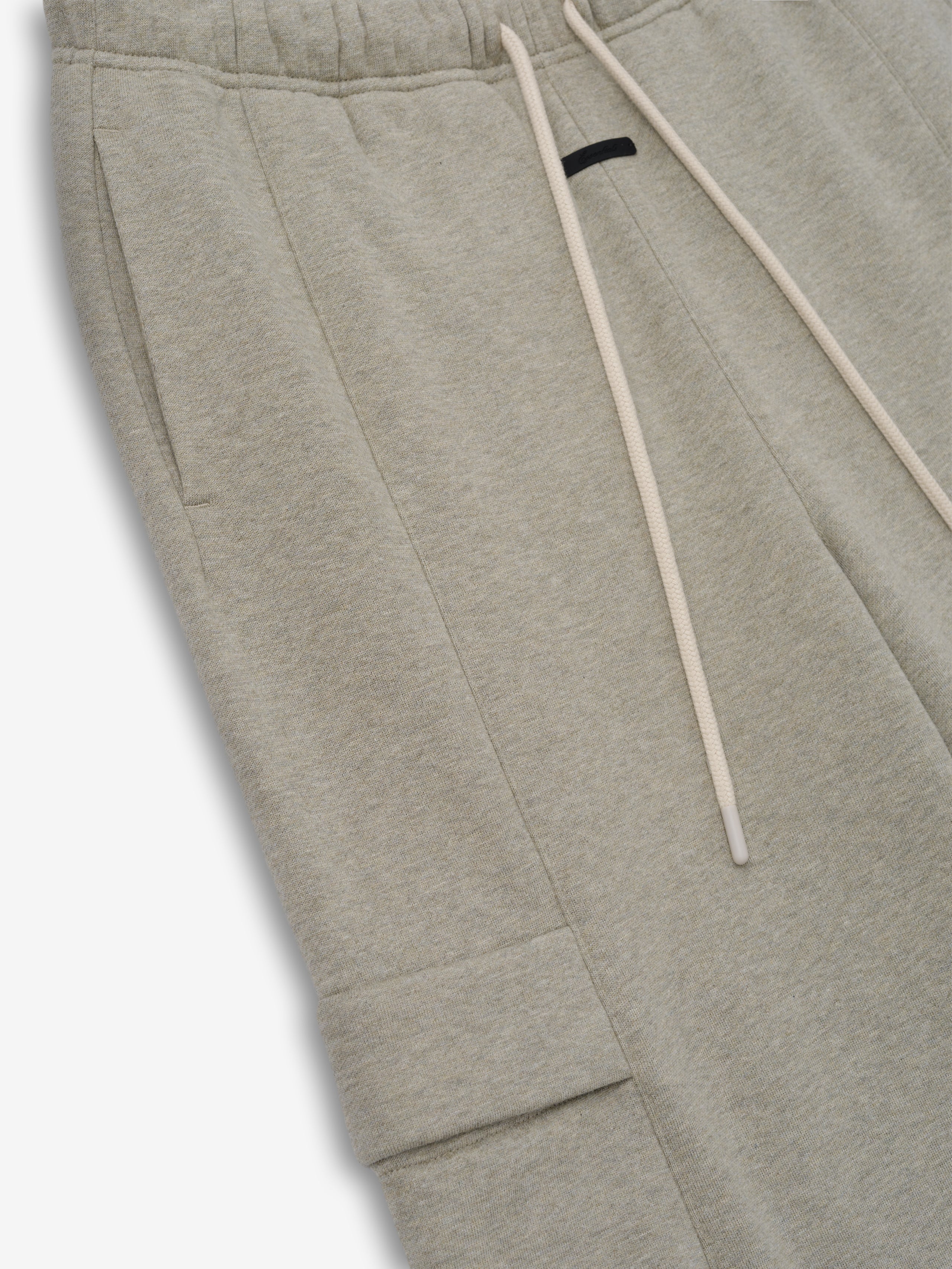 Womens Fleece Cargo Relaxed Sweatpant in a light heathered beige featuring soft fleece fabric, an elastic waistband with long drawstrings, side seam pockets, and a flap cargo pocket for relaxed bottoms.