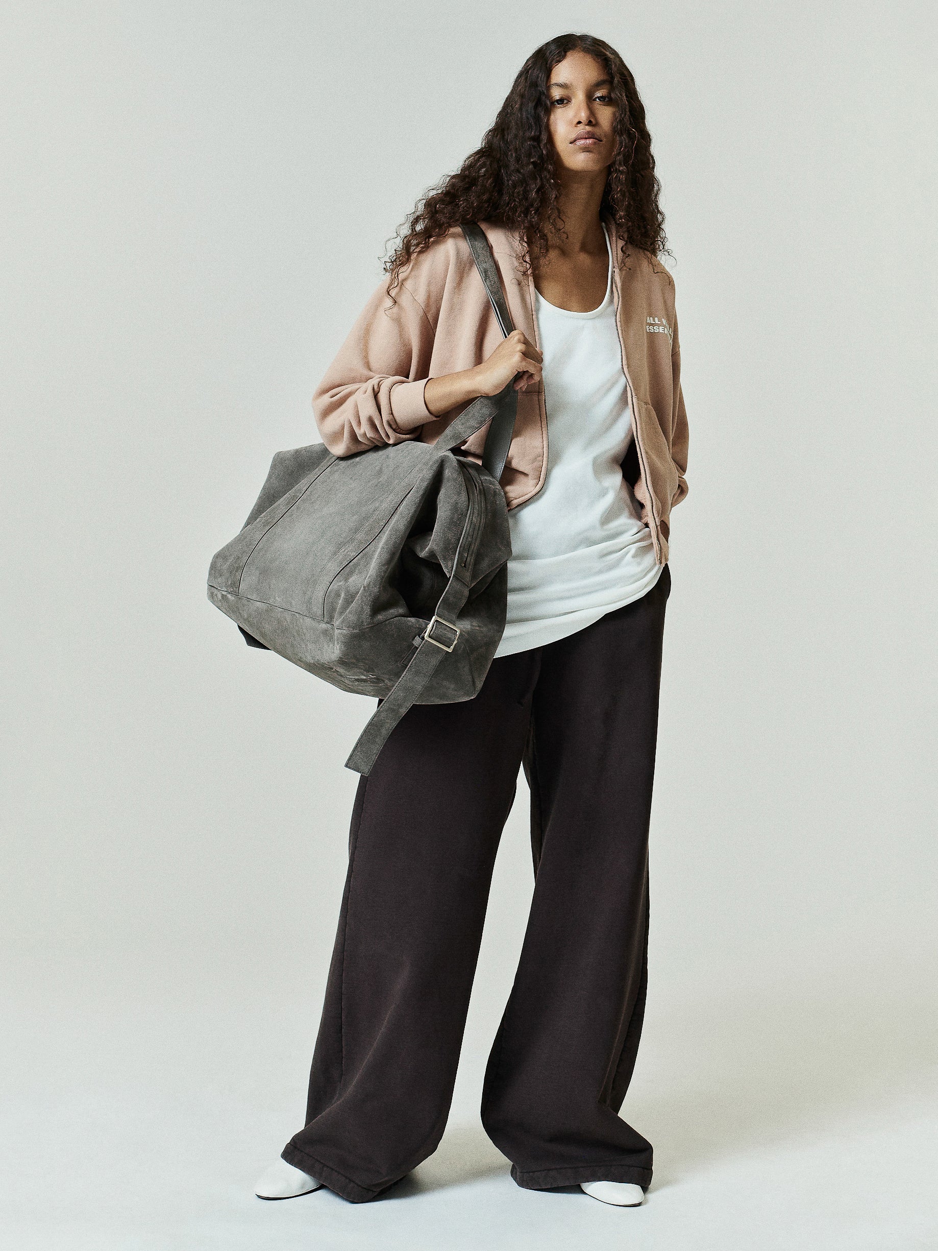 Womens 90s Full Zip Hoodie in a washed ginger tone styled with relaxed black wide-leg pants and a large gray suede tote bag for a casual, effortlessly cool outerwear look.