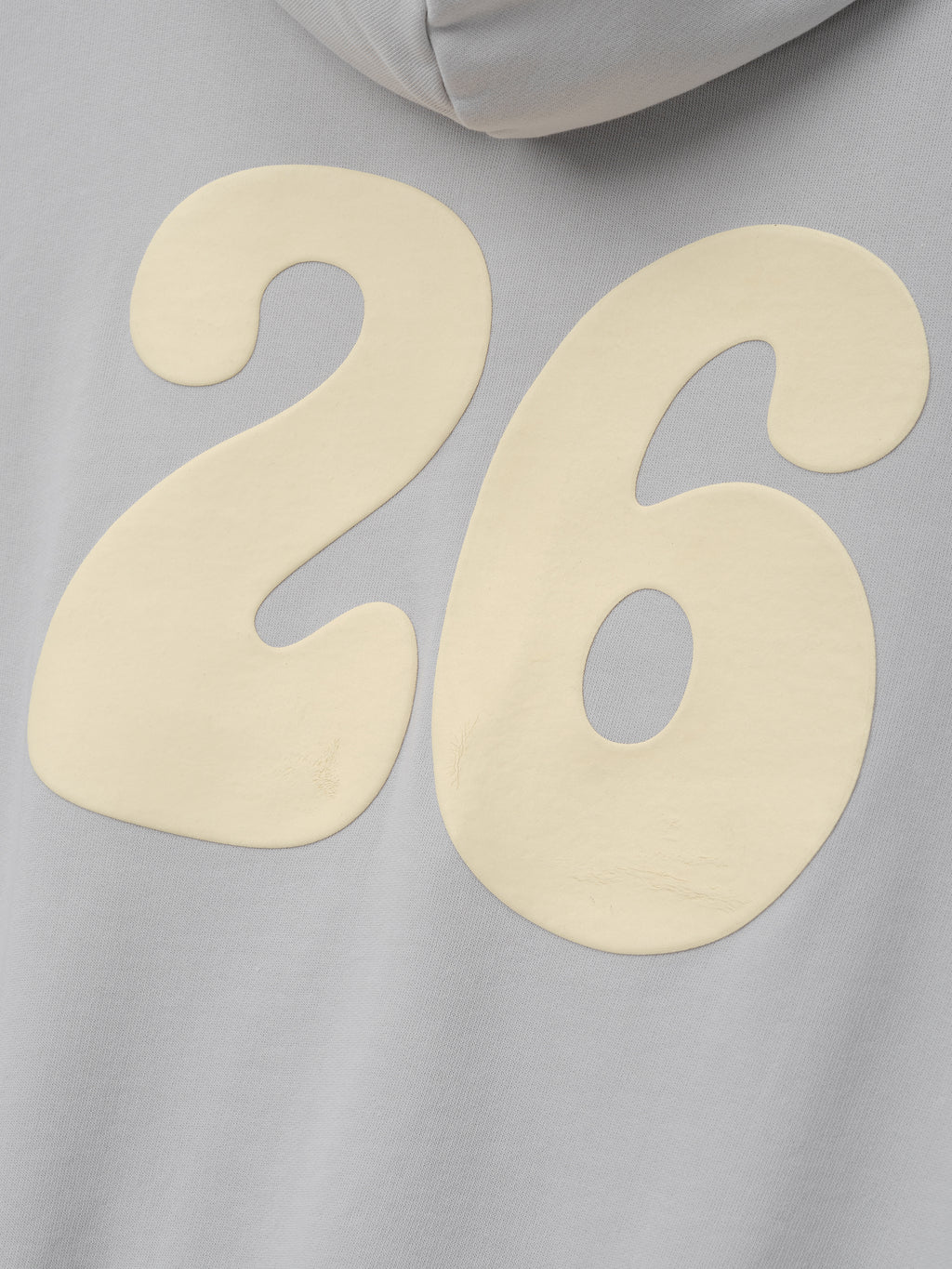 90s Full Zip Hoodie in faded gray fabric featuring a large cream "26" graphic with a slightly textured finish, emphasizing a relaxed and vintage-inspired outerwear style.