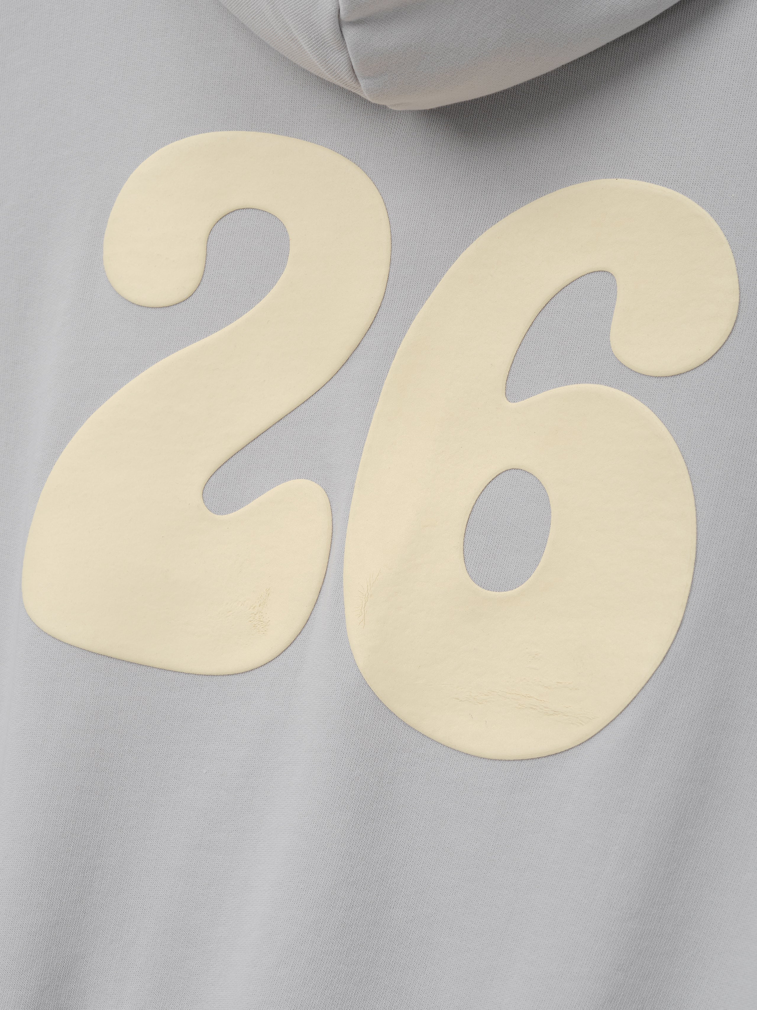 90s Full Zip Hoodie in faded gray fabric featuring a large cream "26" graphic with a slightly textured finish, emphasizing a relaxed and vintage-inspired outerwear style.