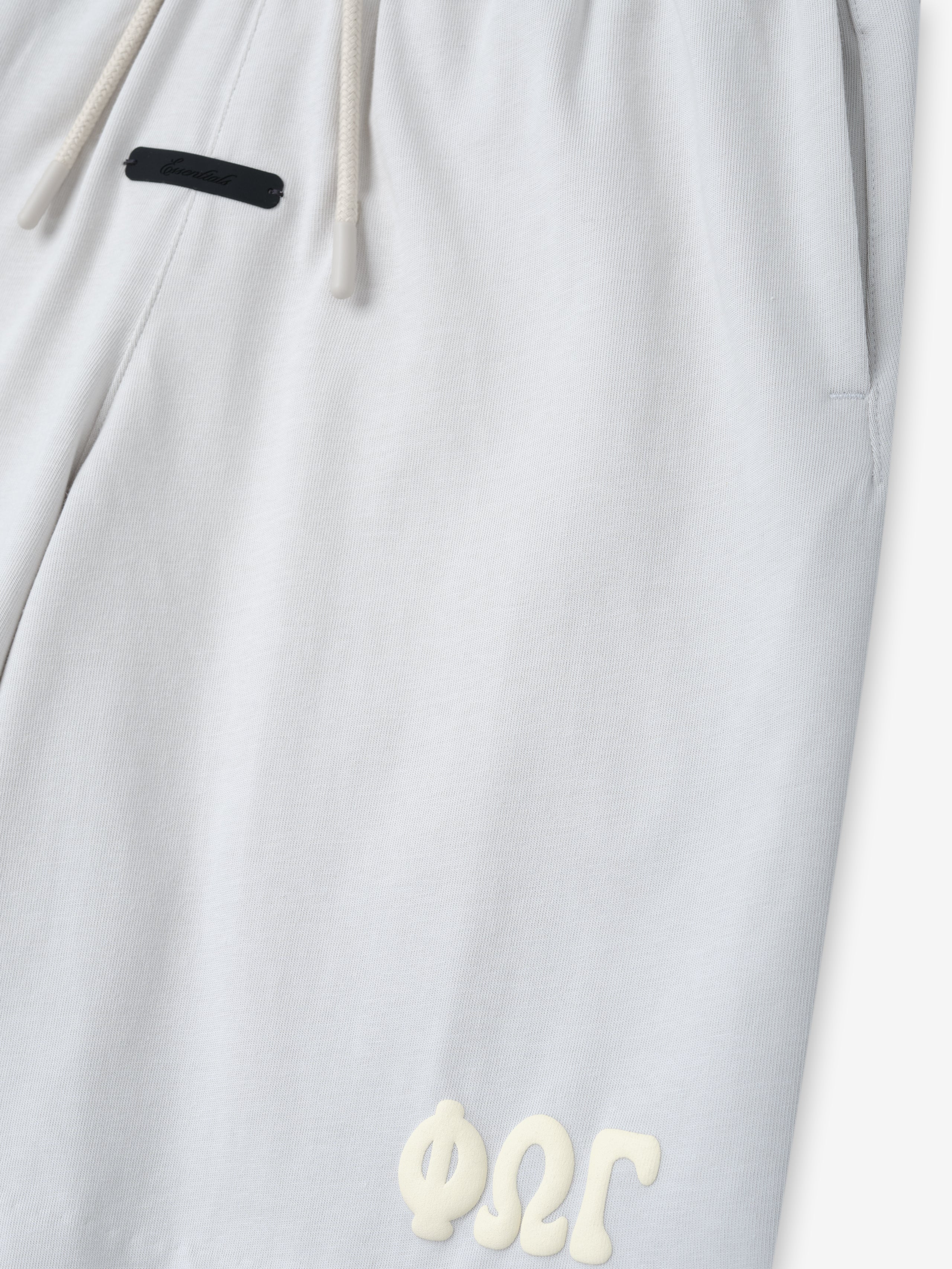 Kids 90'S Jersey Sweatshort in a soft light overcast shade, featuring an elastic waistband with drawstring and a subtle raised cream design near the hem, perfect for casual bottoms.