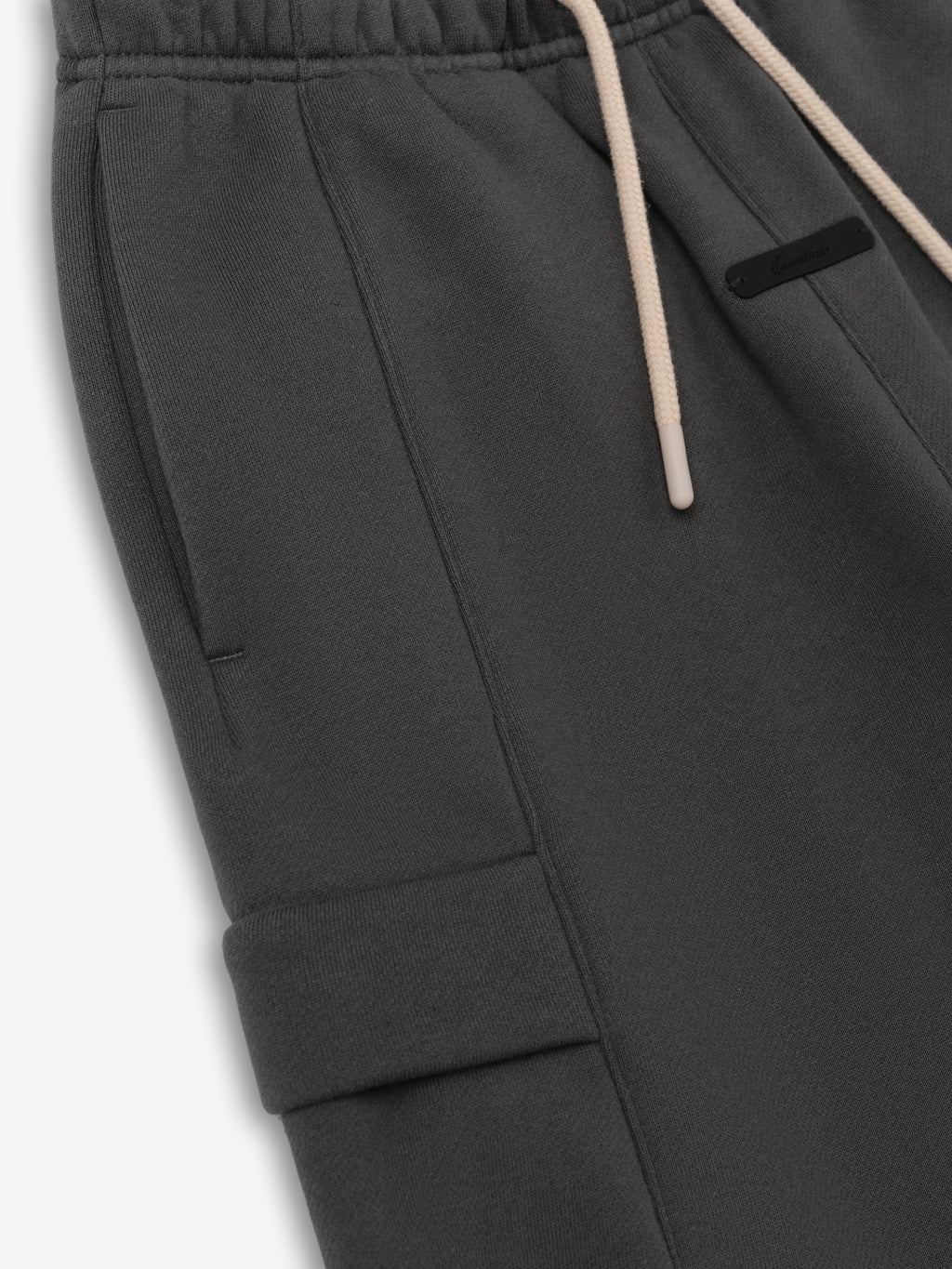 Kids Fleece Cargo Basketball Short in a deep grey tone, featuring an elastic waistband with beige drawstrings, side pockets, and a flap cargo pocket for functional and cozy kids' bottoms.