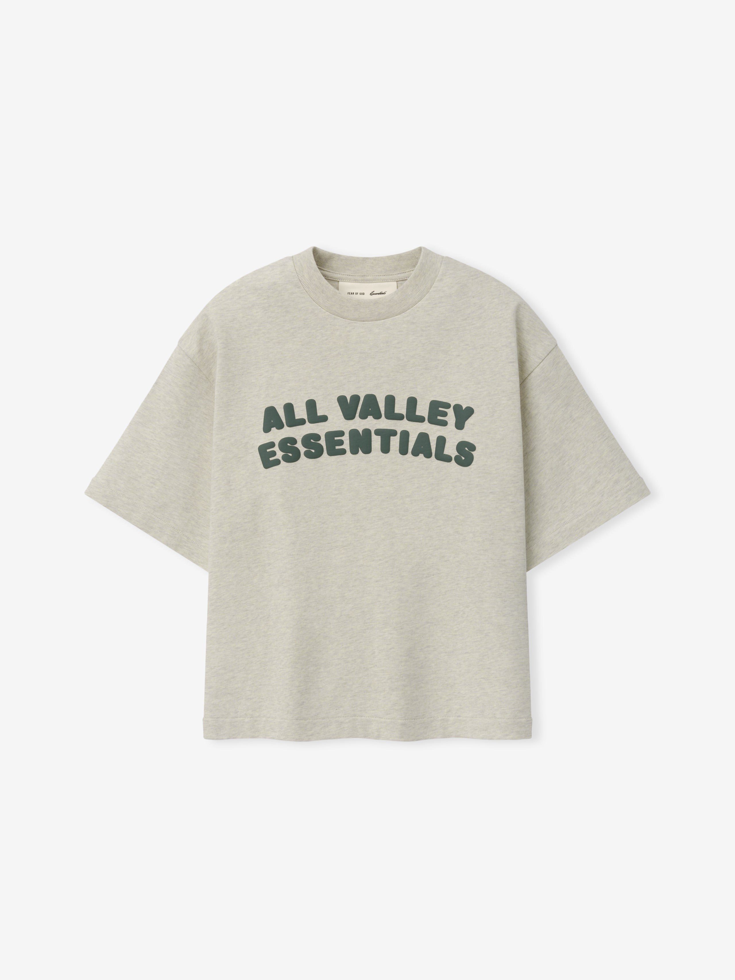 Kids Merch Tee in light vanilla heather fabric featuring dark green rounded text "ALL VALLEY ESSENTIALS" in a relaxed, casual style for a comfortable kids' top.