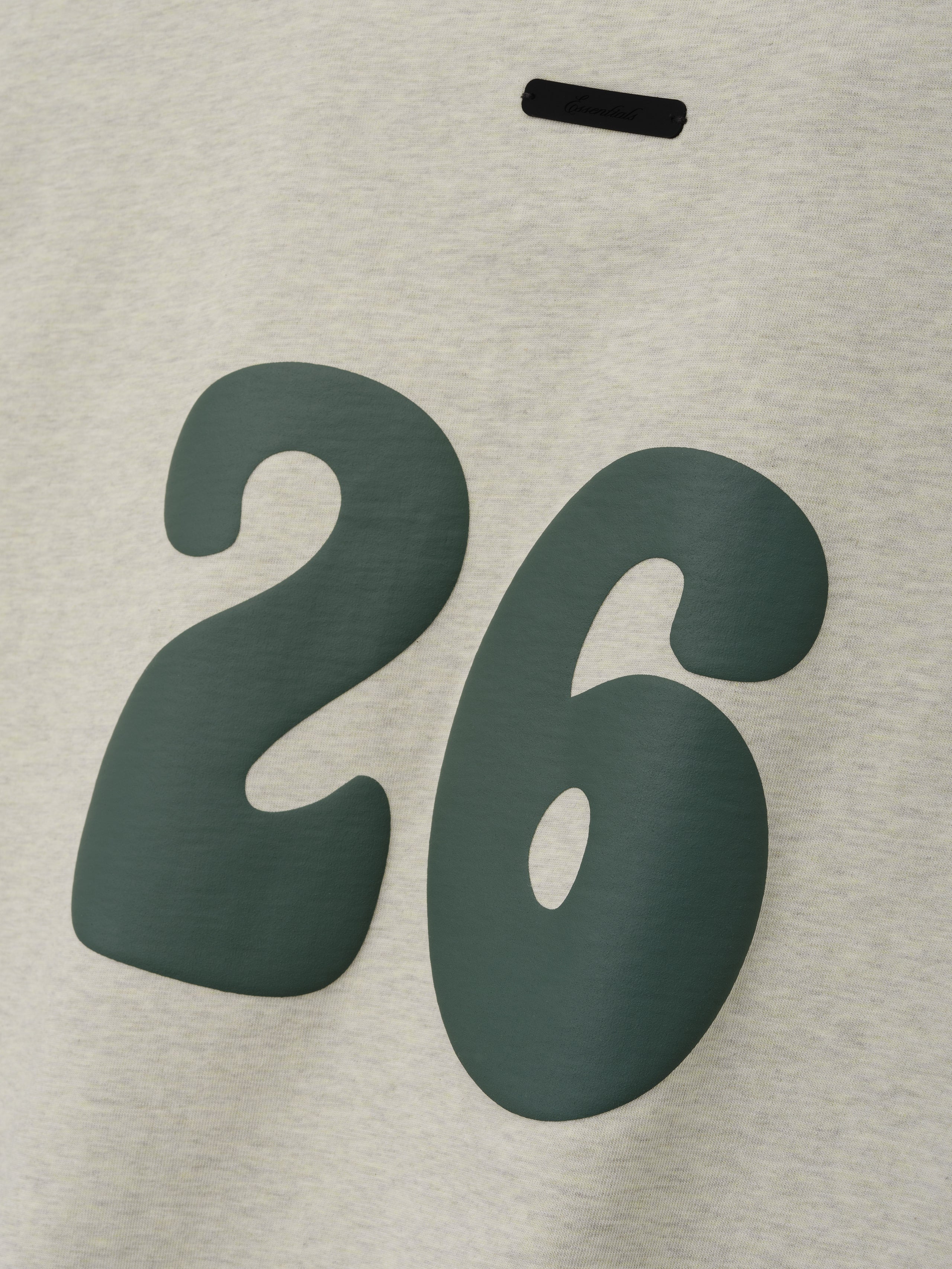 Kids Merch Tee in light vanilla heather fabric featuring a large dark green number "26" in a bold, rounded style for a trendy and comfortable kids' top.