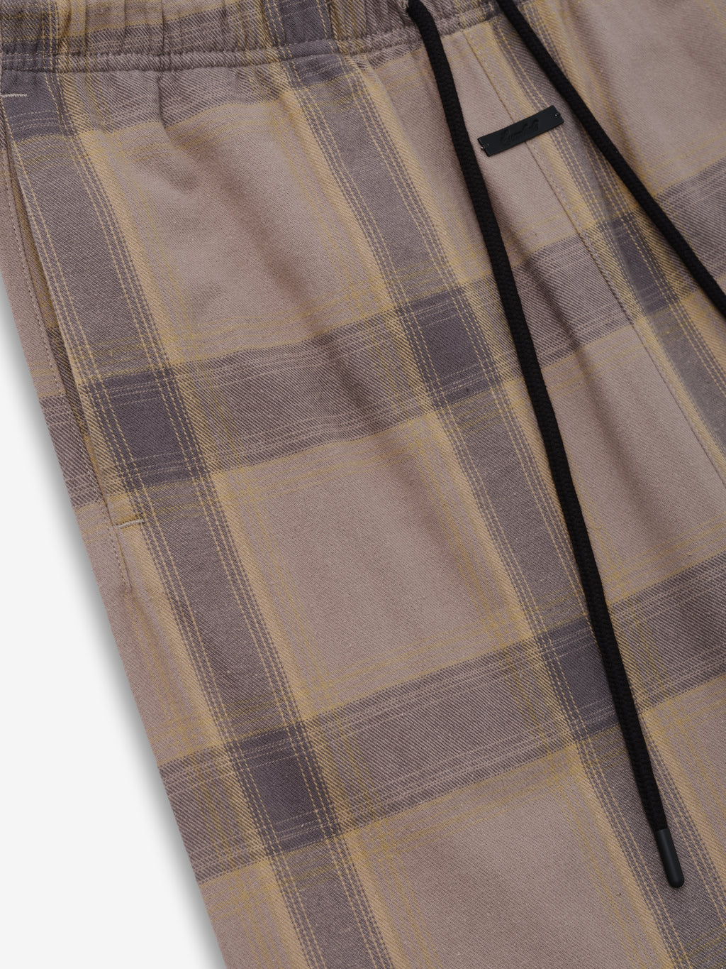 Womens Flannel Lounge Pant in a soft plaid pattern with muted beige and gray tones, featuring an elastic waistband and black drawstrings for a cozy, relaxed fit.