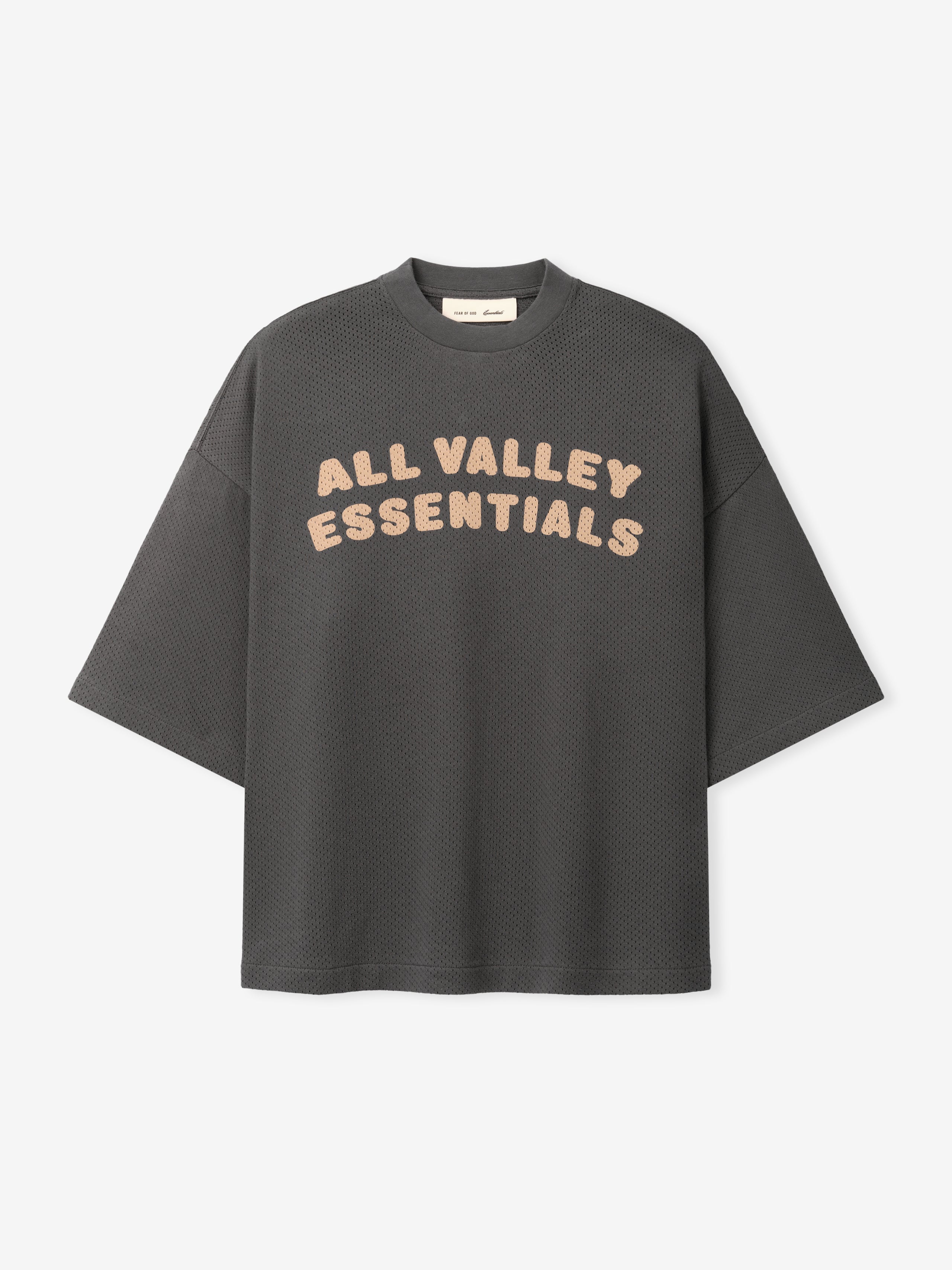 Womens Sport Mesh Merch Tee in dark iron grey featuring breathable textured fabric with relaxed fit and soft peach "ALL VALLEY ESSENTIALS" text across the chest for a casual sporty top.