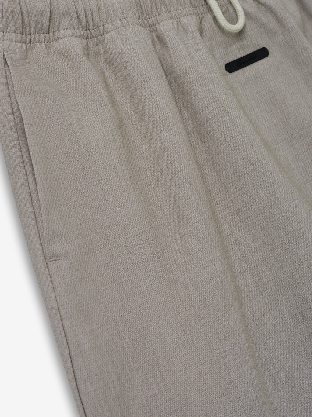 Micro Skirt crafted in a light neutral fabric with subtle texture, featuring an elastic waistband and a small black tag for a refined, comfortable bottom option.