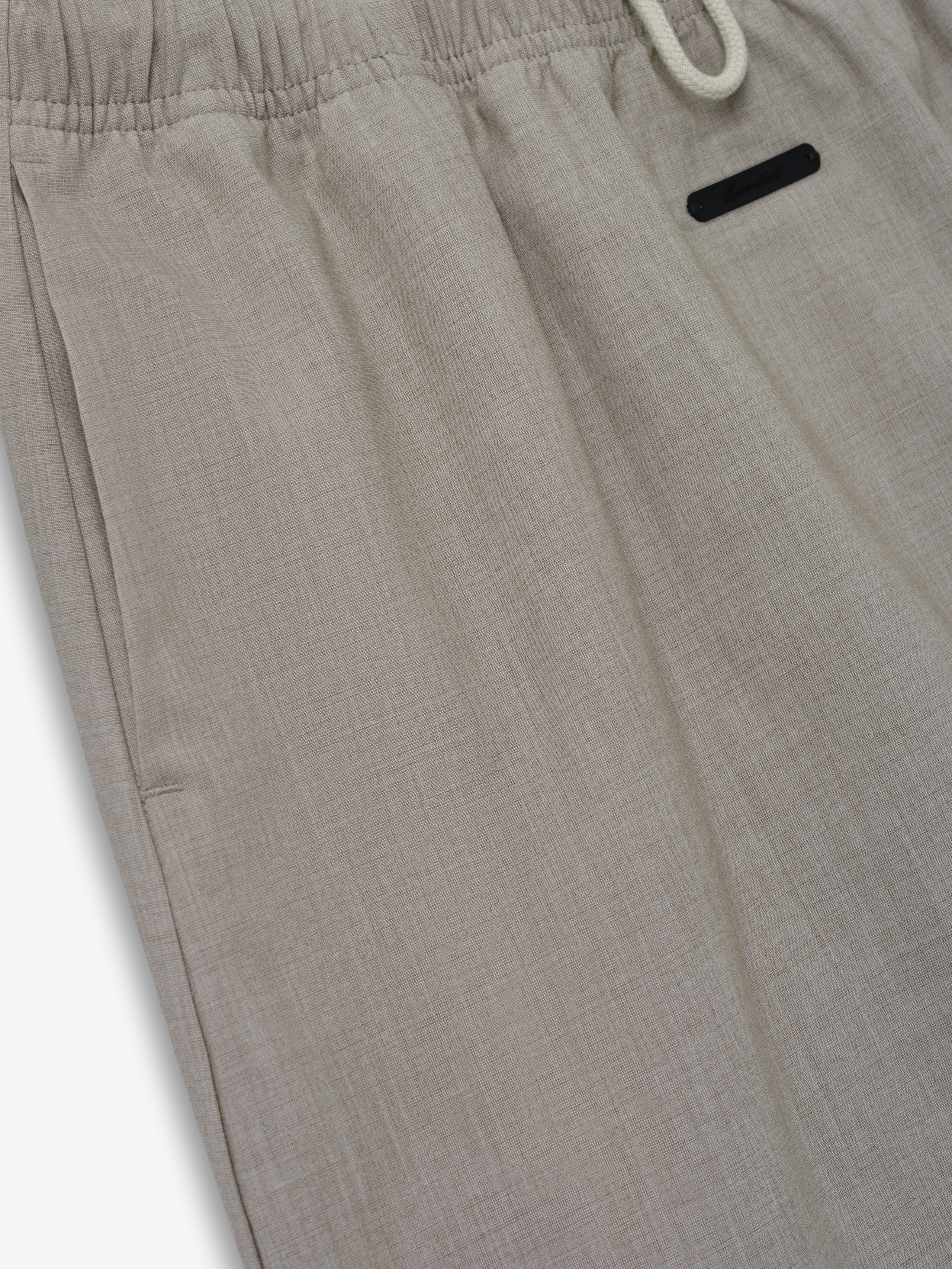 Micro Skirt crafted in a light neutral fabric with subtle texture, featuring an elastic waistband and a small black tag for a refined, comfortable bottom option.