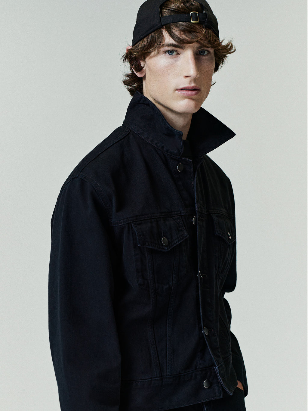 Classic Denim Jacket in an overdyed black shade featuring a high collar, button-front closure, chest flap pockets, and durable denim fabric for versatile outerwear style.