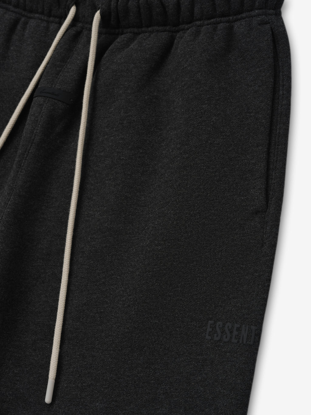 Classic Fleece Sweatpant in dark grey heather with an elastic waistband, long beige drawstrings, side pockets, and subtle tonal branding for a minimalist casual look.