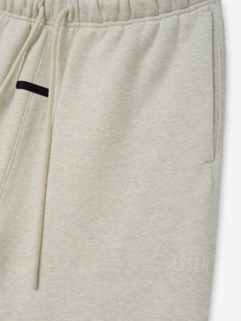 Classic Fleece Sweatpant in a light vanilla shade featuring an elastic waistband with long drawstrings, side pockets, and subtle tonal branding near the hem for relaxed casual bottoms.