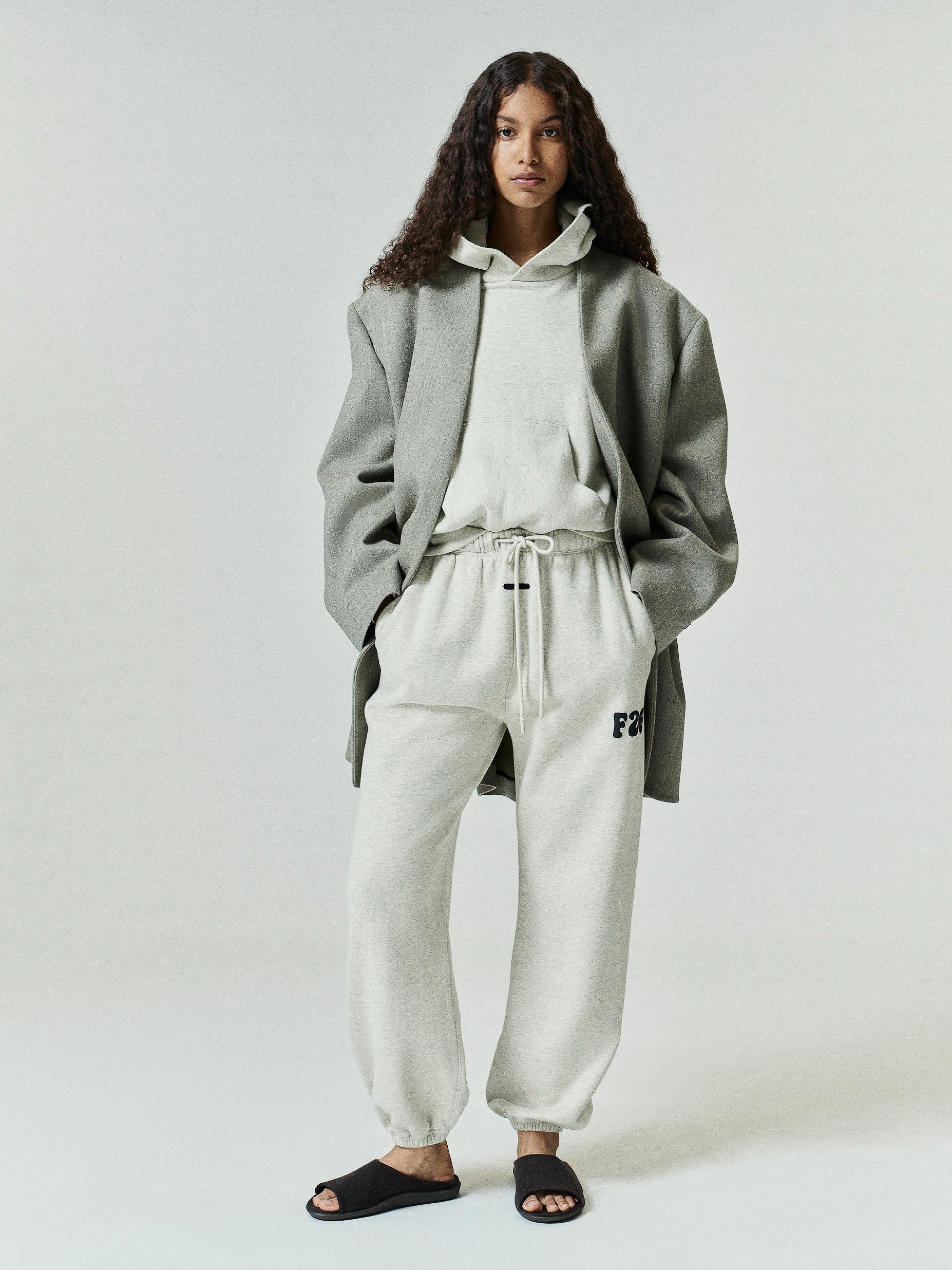 Womens Classic Fleece Sweatpant in a soft washed ivory tone with adjustable drawstring waist, elastic cuffs, side pockets, and subtle F26 branding on the thigh for relaxed casual bottoms.