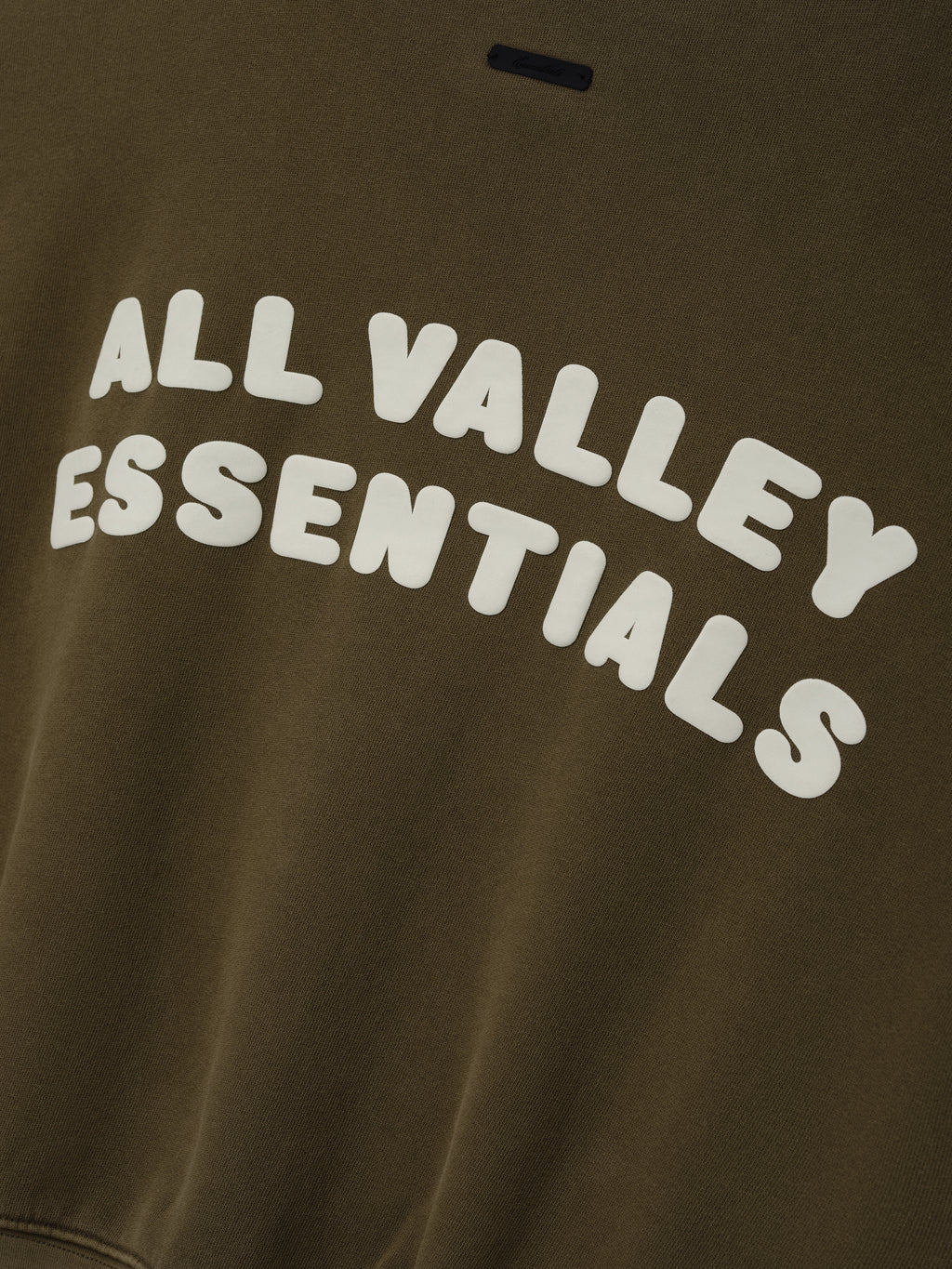 Womens French Terry Relaxed Half Zip in a muted olive green tone, featuring bold white embossed lettering “All Valley Essentials” across the chest for a stylish casual top.