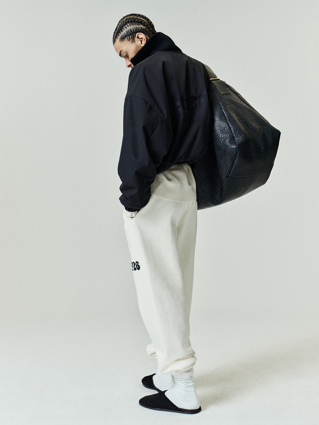 Classic Fleece Sweatpant in a soft washed ivory tone, featuring a relaxed fit with a high-rise waist, elastic cuffs, side pockets, and a black logo detail on the left thigh for casual bottoms.