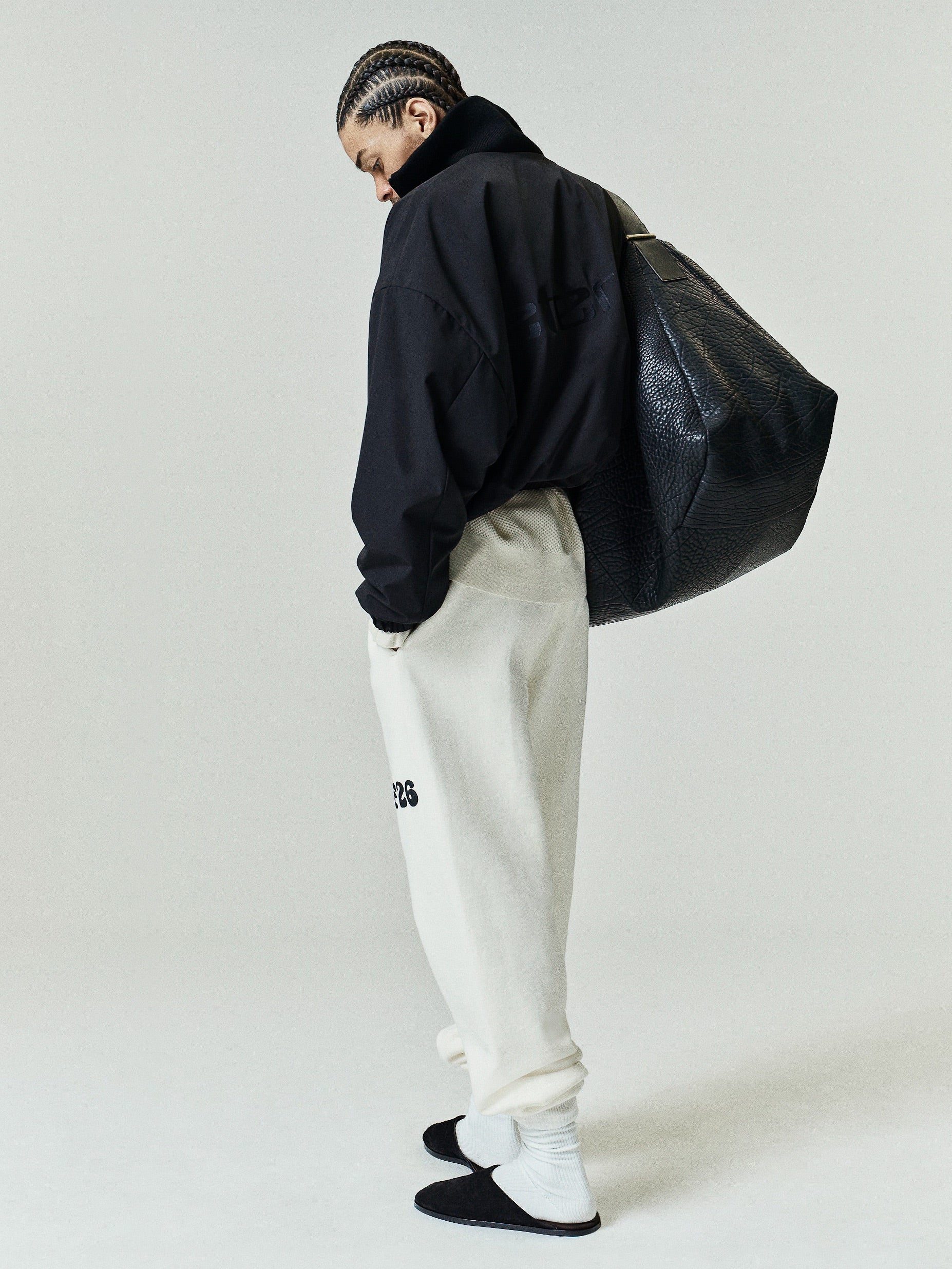 Classic Fleece Sweatpant in a soft washed ivory tone, featuring a relaxed fit with a high-rise waist, elastic cuffs, side pockets, and a black logo detail on the left thigh for casual bottoms.
