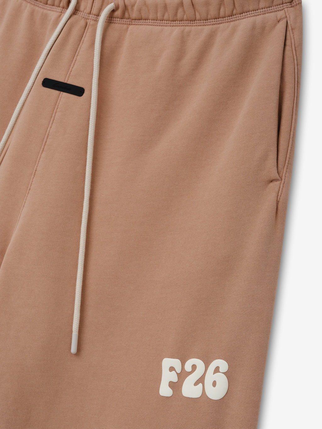 Classic Fleece Sweatpant in a washed ginger shade featuring an elastic waistband with cream drawstrings, side pockets, and a raised F26 logo near the hem for relaxed casual bottoms.