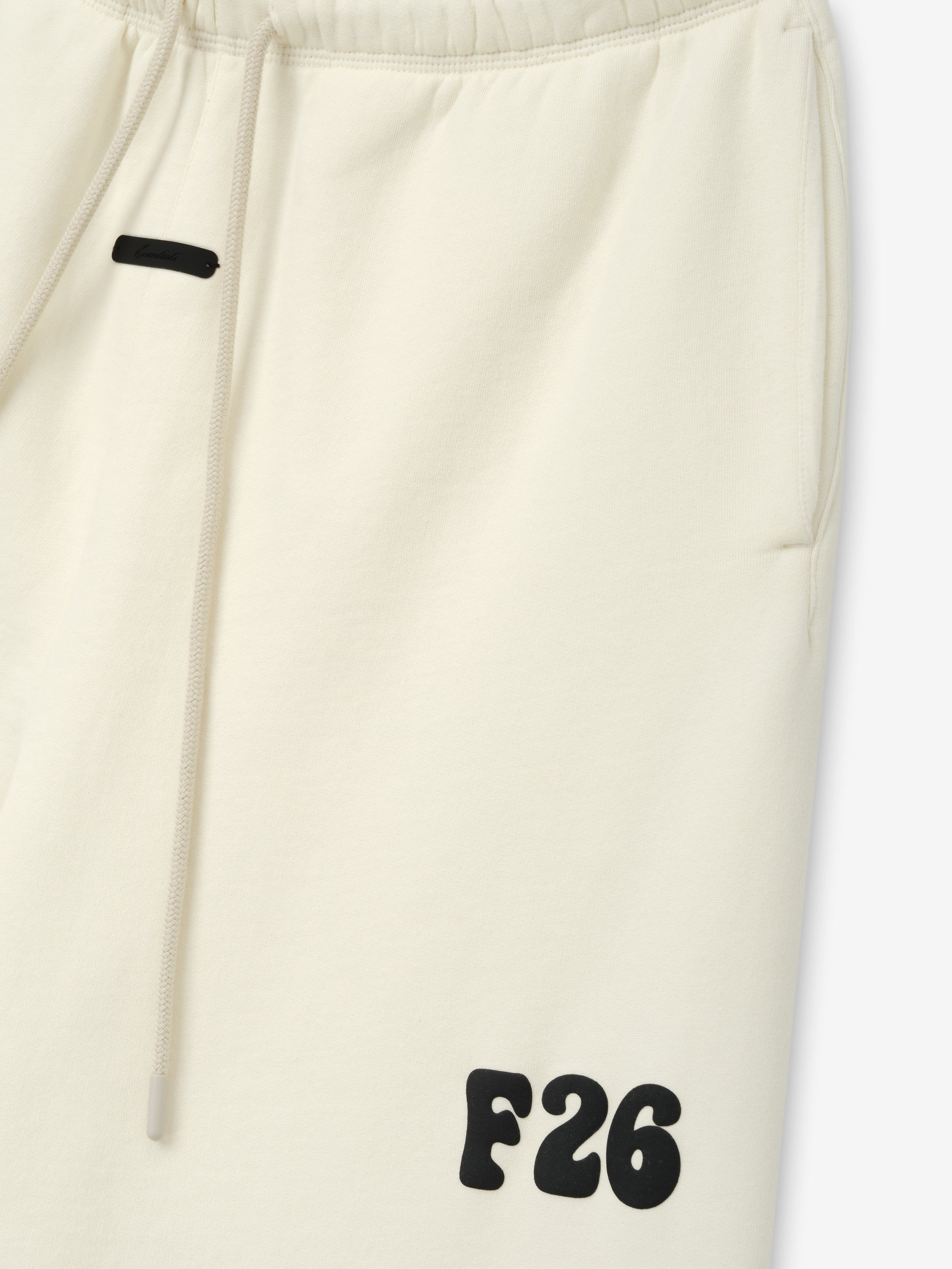 Classic Fleece Sweatpant in a soft washed ivory color with an elastic waistband, drawstring, side pockets, and a bold black F26 logo on the lower leg for casual bottoms.