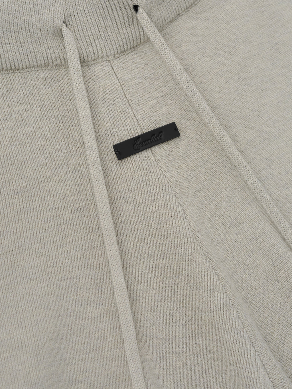 Womens Soft Knit Running Short in a soft neutral tone, featuring a ribbed waistband with matching drawstrings and a subtle black branded tag for a refined casual bottom.