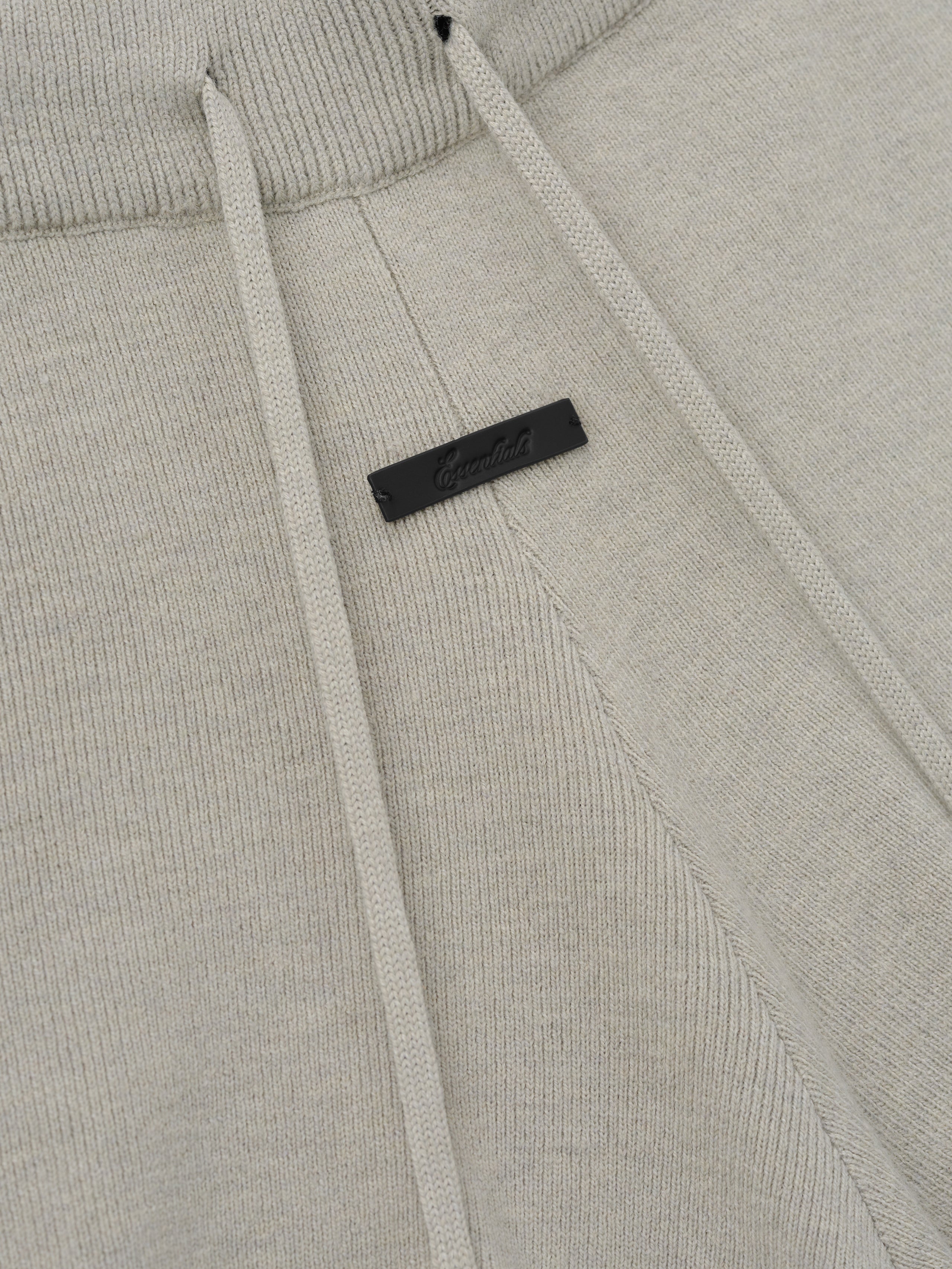 Womens Soft Knit Running Short in a soft neutral tone, featuring a ribbed waistband with matching drawstrings and a subtle black branded tag for a refined casual bottom.
