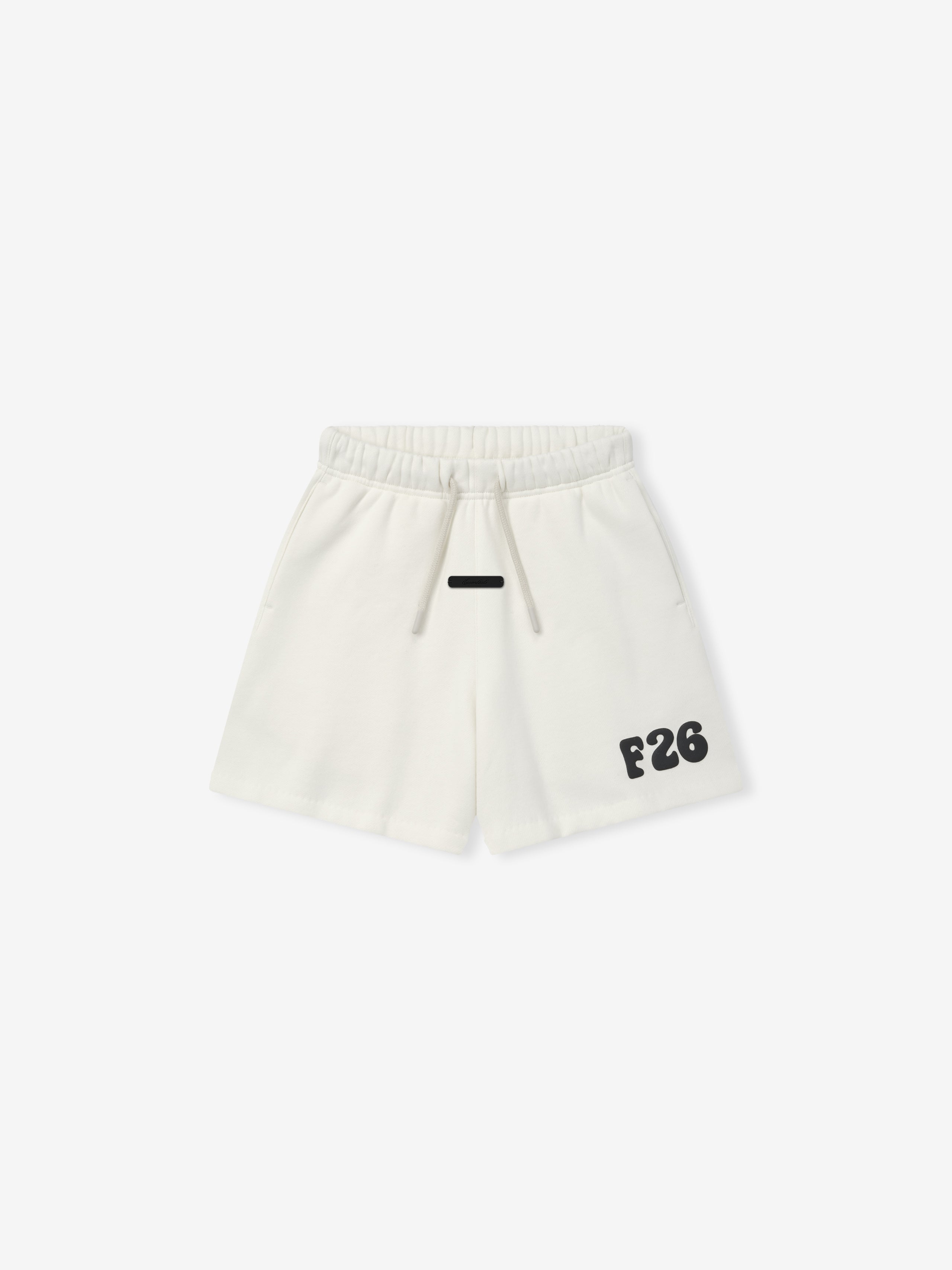 Kids Classic Sweatshort in a soft ivory shade with an elastic waistband and adjustable drawstrings, featuring bold black printed detailing on the front for casual kids bottoms.