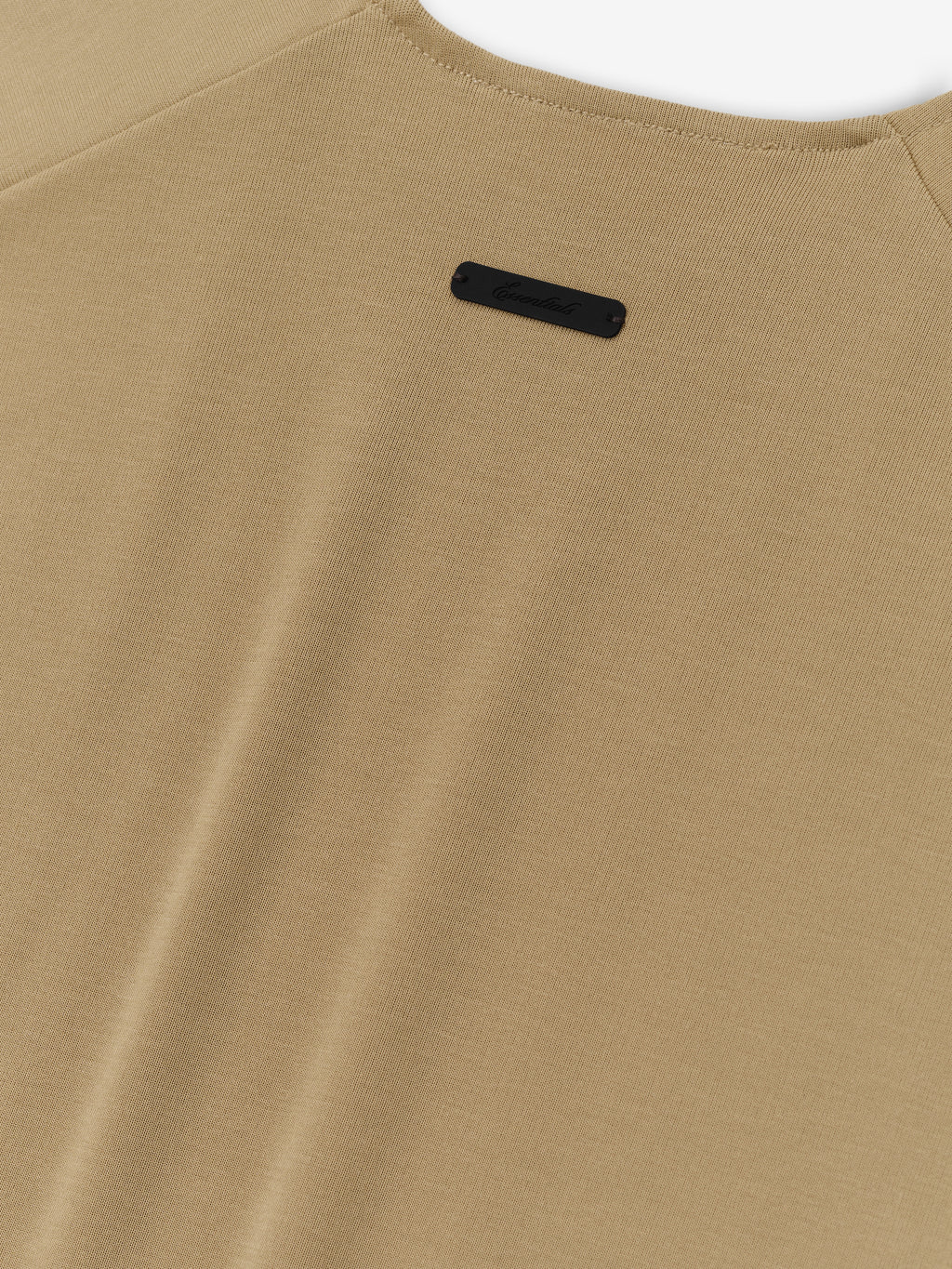 Womens Soft Rib Fitted Tank in a muted dune beige, featuring a smooth ribbed fabric with a minimalist back neckline and a small black logo patch for subtle branding.