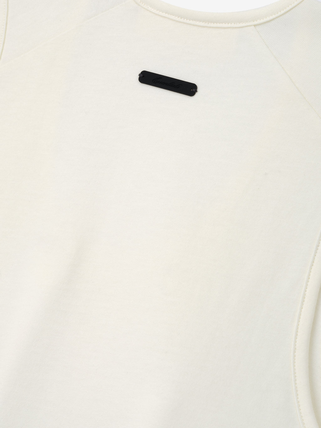 Womens Tri-Blend Classic Tank in a soft ivory color featuring a smooth fabric with a close-up of a small black tag detail near the neckline for subtle branding on this casual top.
