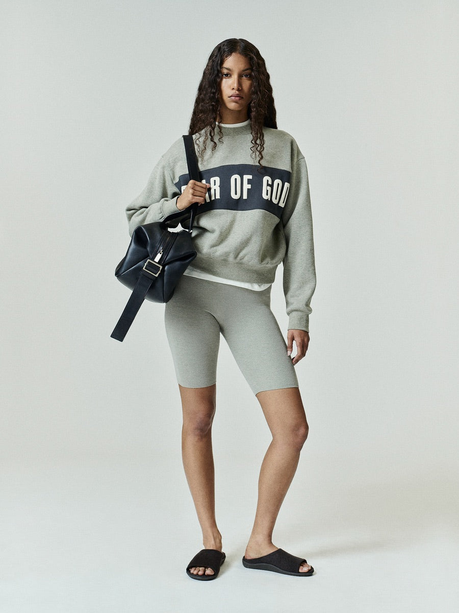 Womens Paneled Classic Sweatshirt in a muted gray with a bold black panel across the chest showcasing large Fear of God lettering, styled as relaxed outerwear.