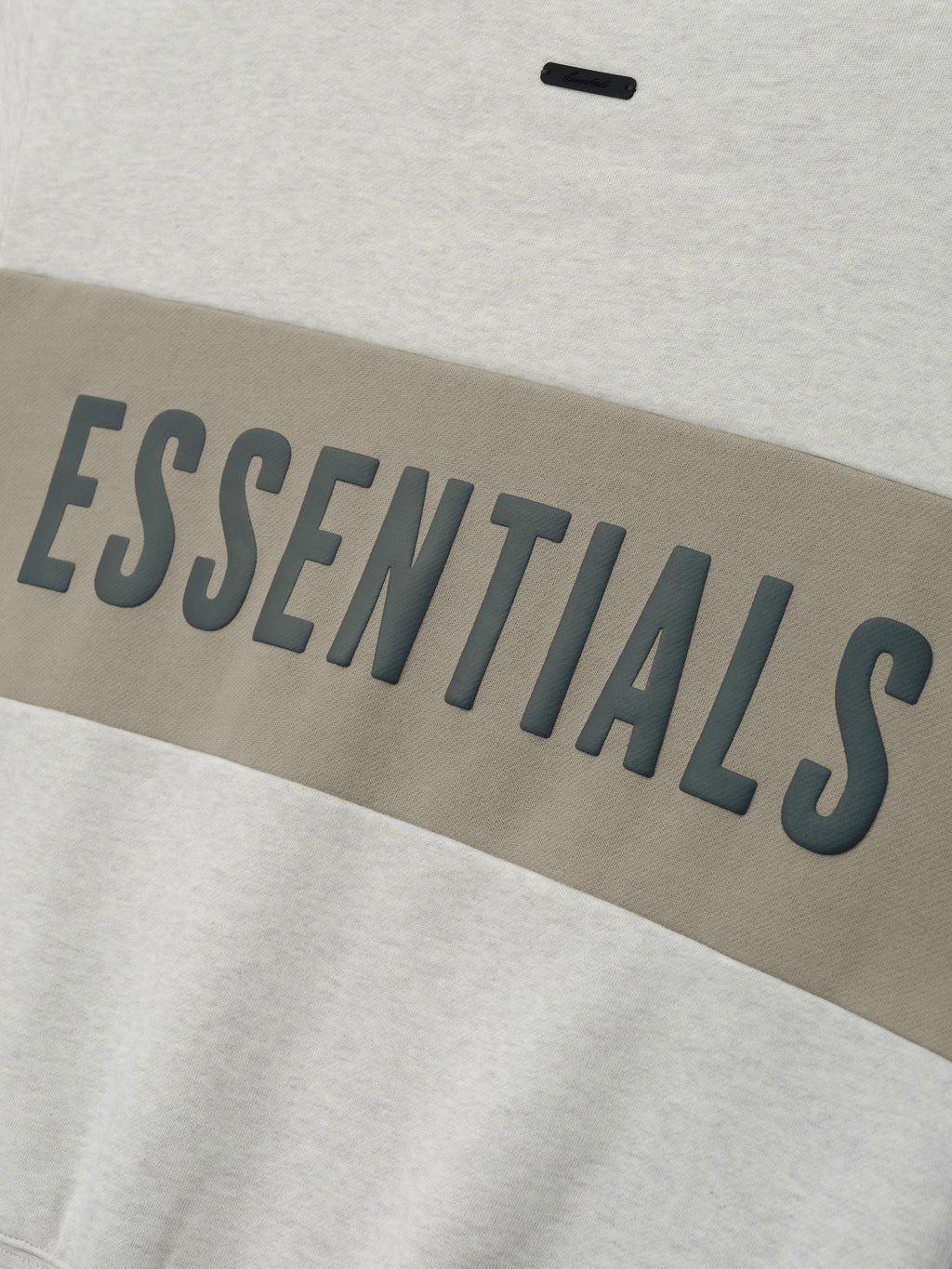 Womens Paneled Classic Sweatshirt in a soft vanilla heather tone with a wide muted taupe panel across the chest showcasing raised dark gray ESSENTIALS lettering, casual outerwear top.