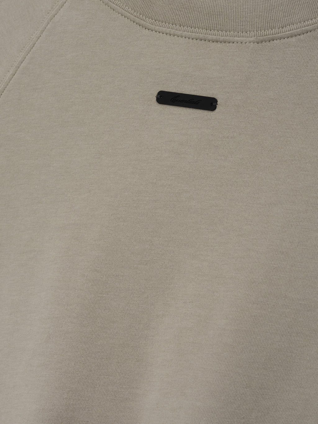 Womens Shrunken Baseball Tee in a muted seal green shade featuring a minimalist black branded patch on the upper back, crafted from soft fabric for casual tops.