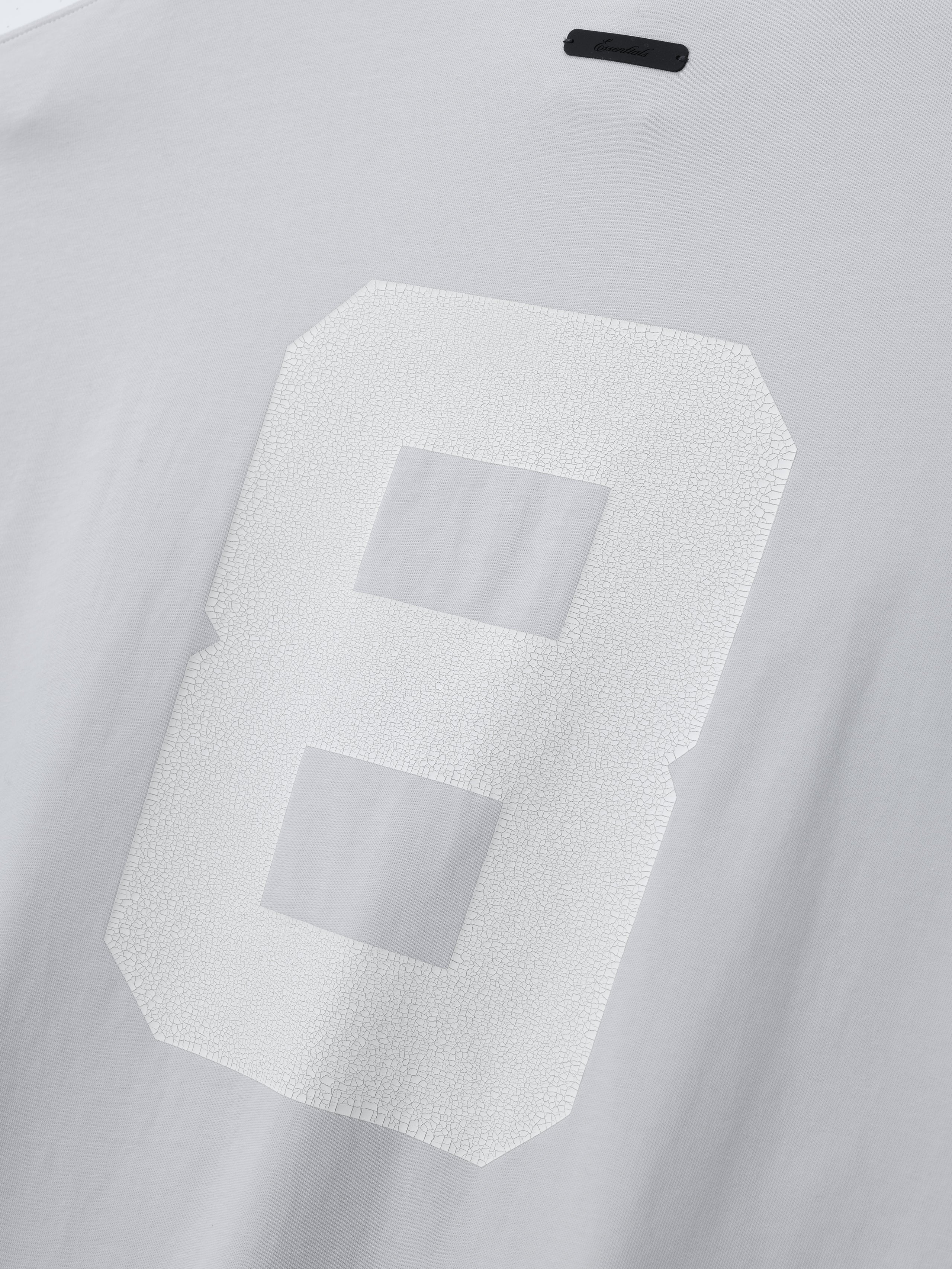Merch Long Sleeve Tee in soft light grey featuring a large textured number 8 printed on the back for a clean, casual look in premium Fear of God tops.