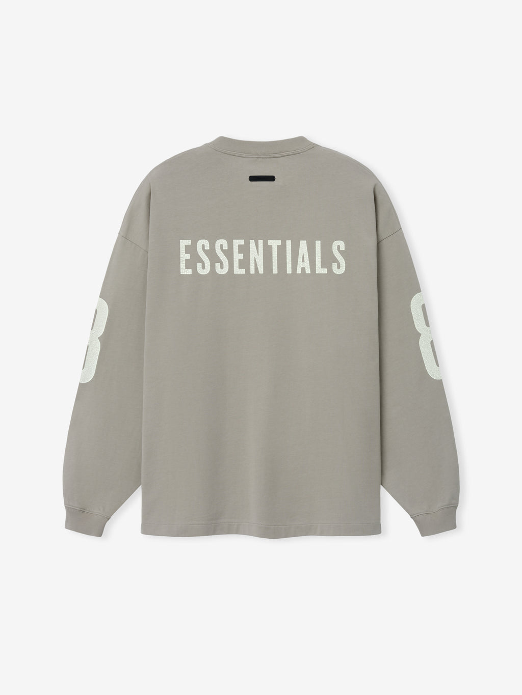 Merch Long Sleeve Tee in muted taupe showcasing bold "ESSENTIALS" text across the upper back and large contrasting numbers on each sleeve for a streetwear-inspired look.
