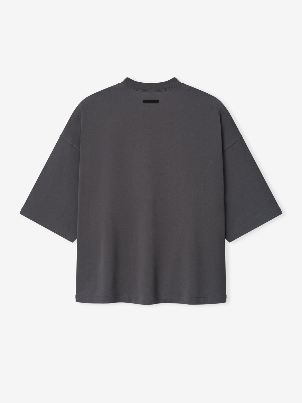 Merch Tee in dark grey featuring an oversized relaxed fit with dropped shoulders and a small black rectangular detail near the neckline for a minimalist casual top.
