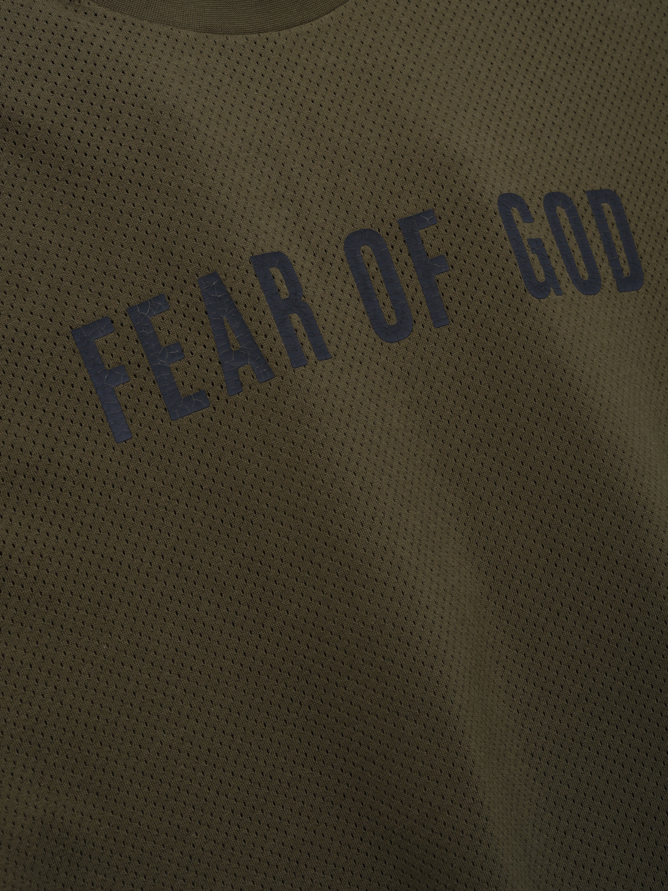 Sport Mesh Merch Long Sleeve Tee in olive mesh fabric featuring curved dark navy "Fear of God" text across the chest for a modern and breathable streetwear top.