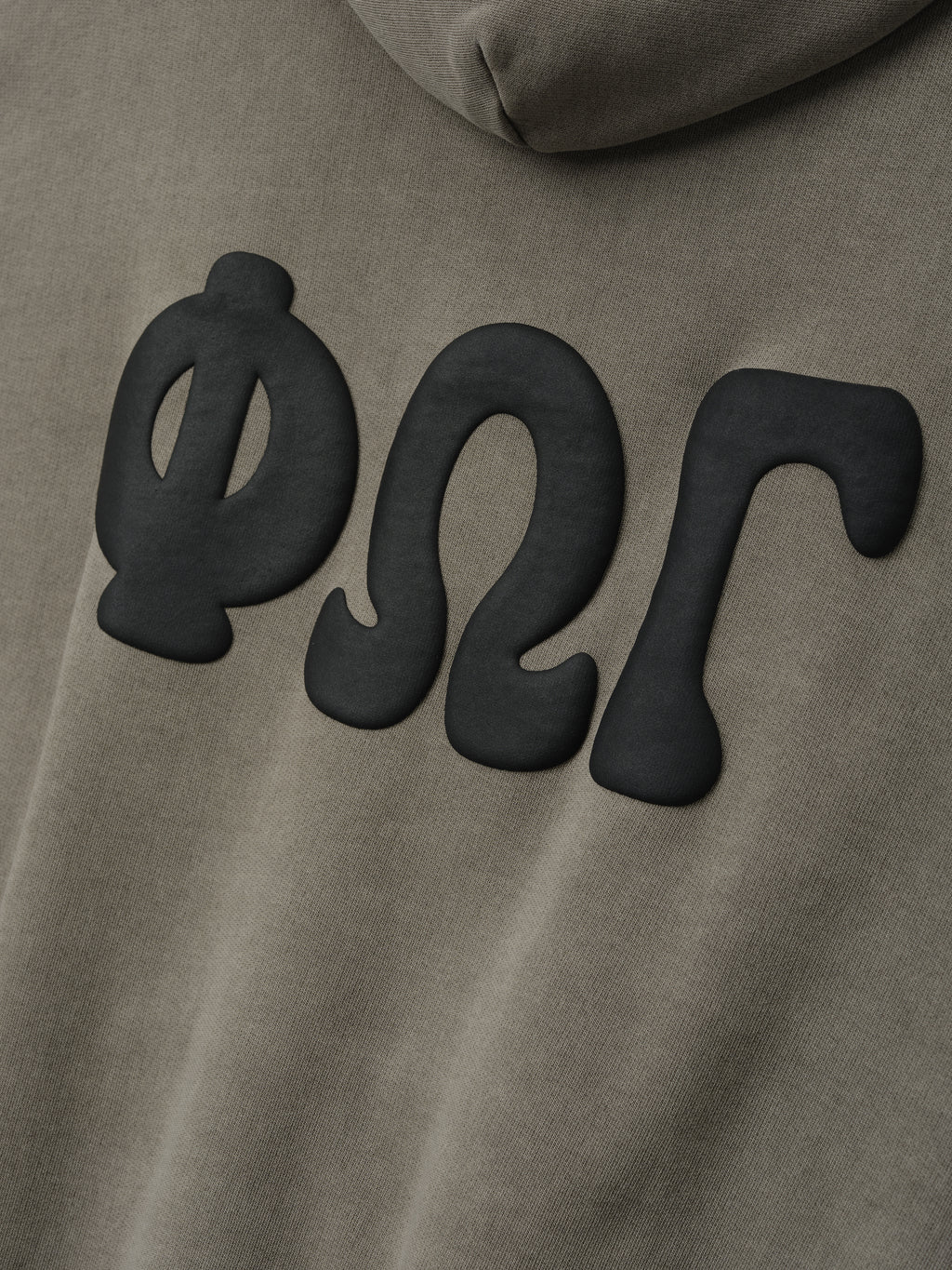 90'S Zip-Up Hoodie in a muted washed seal color featuring soft fabric with large matte black Greek letter appliqués on the back for distinctive outerwear style.