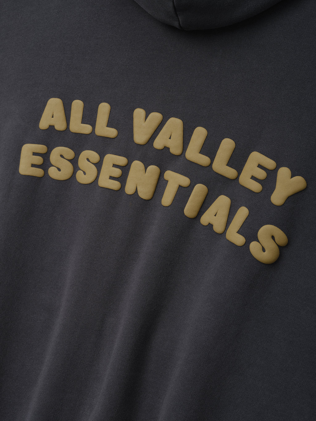 90'S Zip-Up Hoodie in a dark washed iron grey featuring a soft fabric with raised beige graphic lettering across the back for distinctive outerwear style.