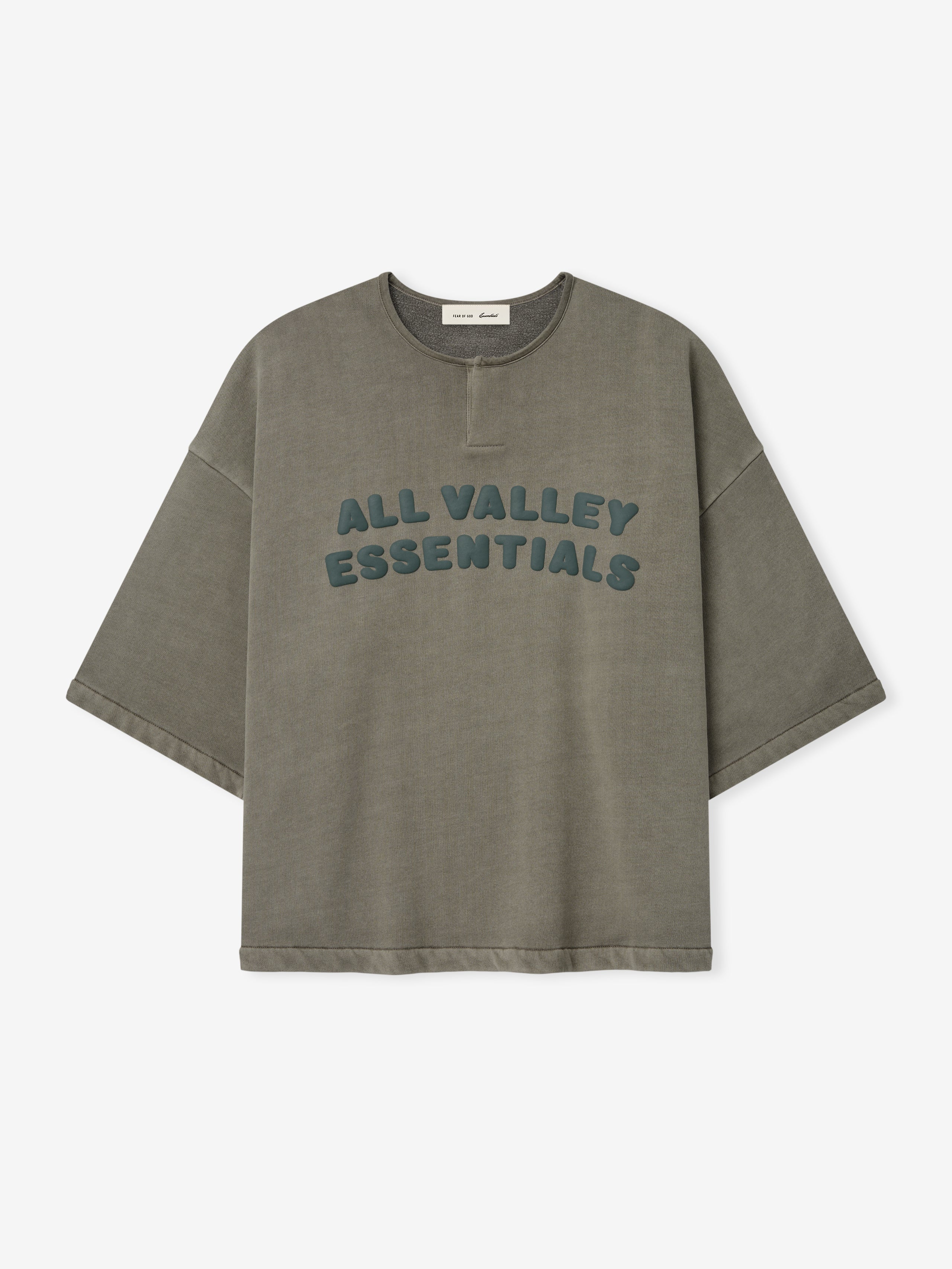 Front view of an olive washed 3/4 Henley Sweatshirt with dropped shoulders, wide sleeves, and raised teal lettering reading "ALL VALLEY ESSENTIALS" across the chest.