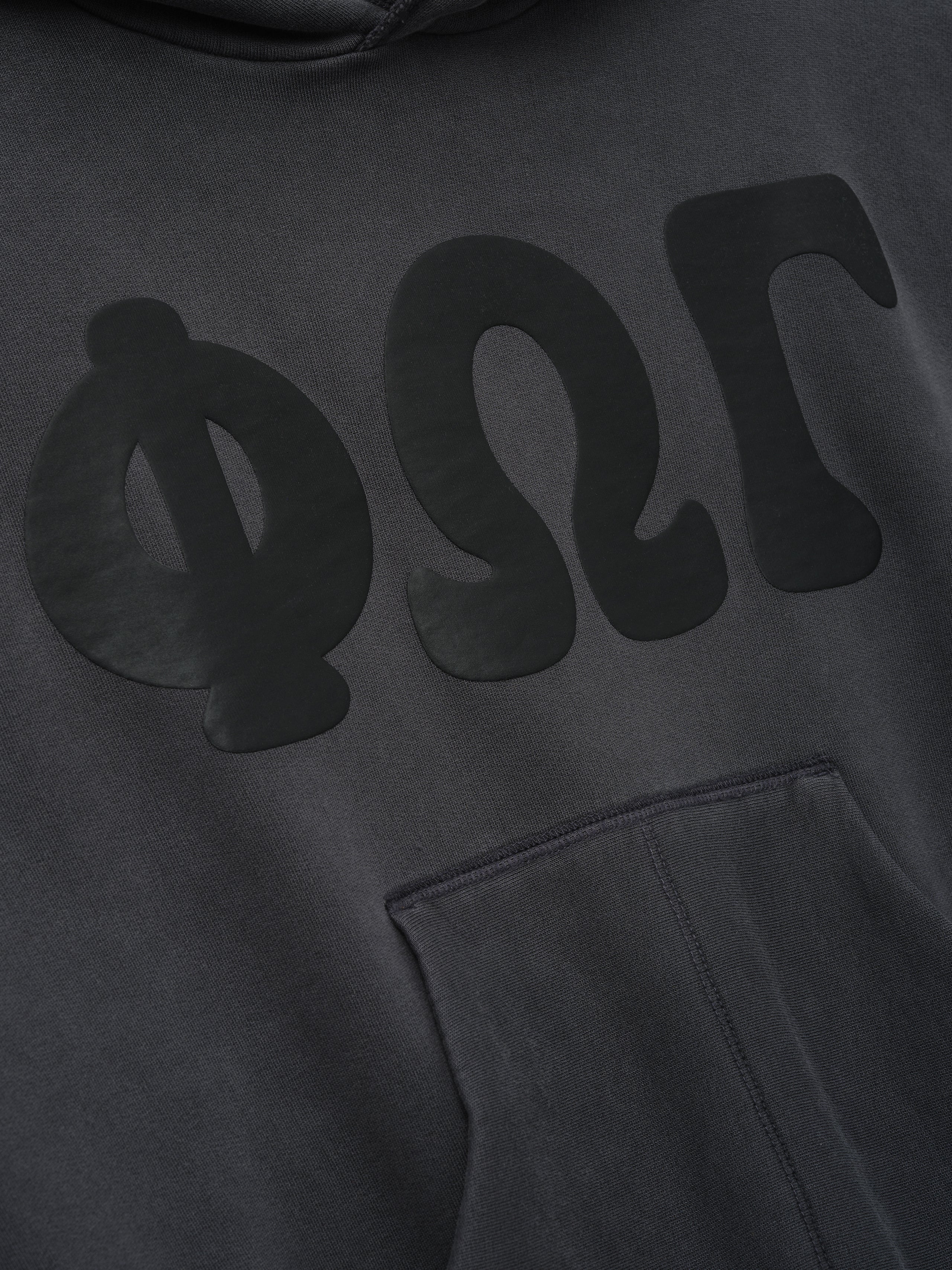 Womens 90s Fleece Hoodie in dark washed iron grey featuring a close-up of the front with subtle tonal Greek letters and a softly textured kangaroo pocket.