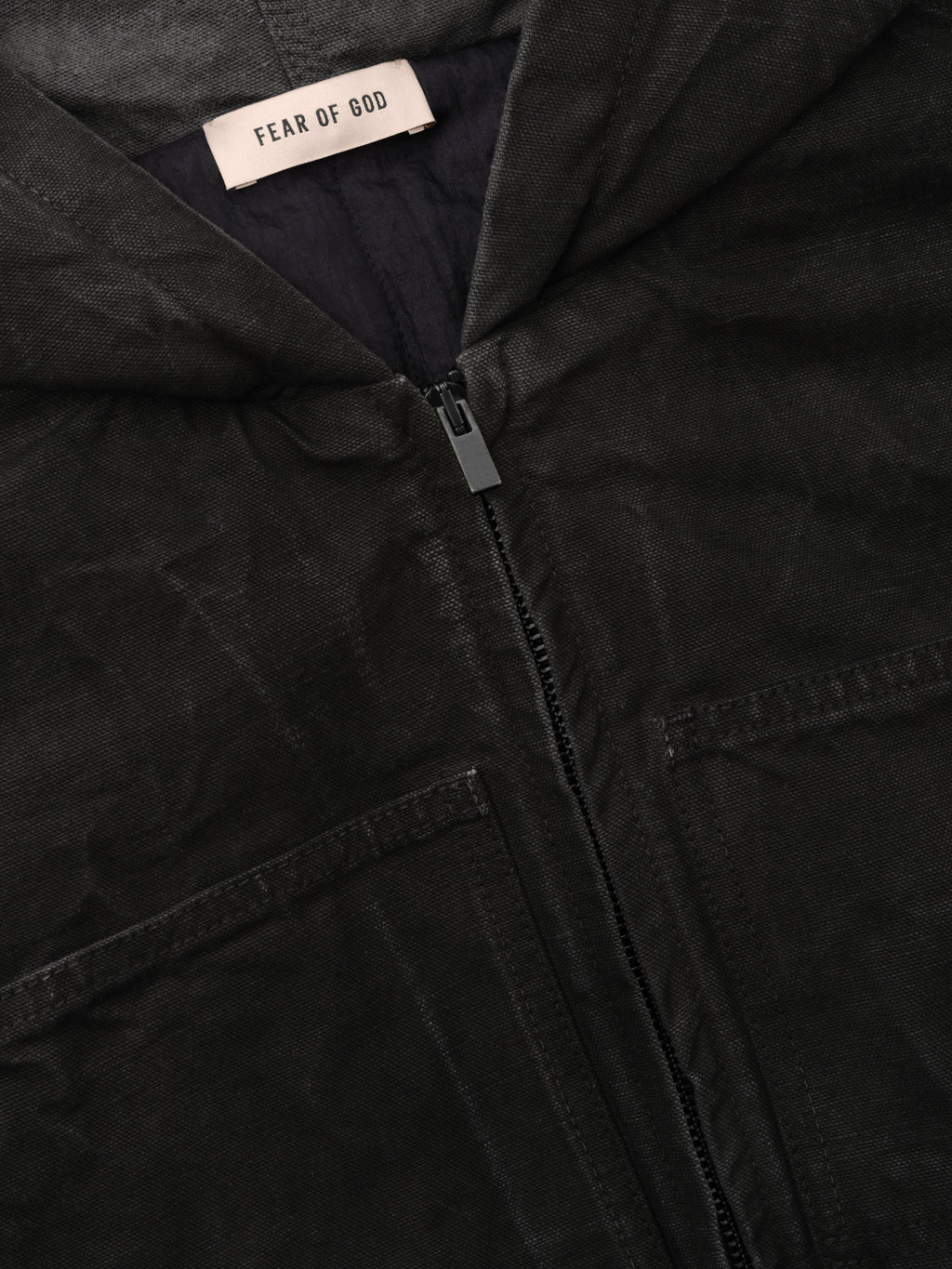 Canvas Workwear Hooded Bomber in black shown close up with a Fear of God label front zip closure hood and angled welt pockets as outerwear
