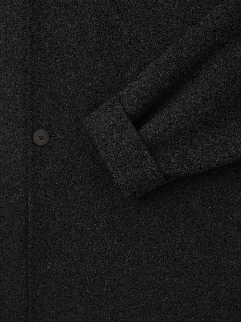 Double Face Wool Cashmere Overcoat in black shown in close detail with a sleeve cuff and button highlighting the soft textured fabric as Outerwear