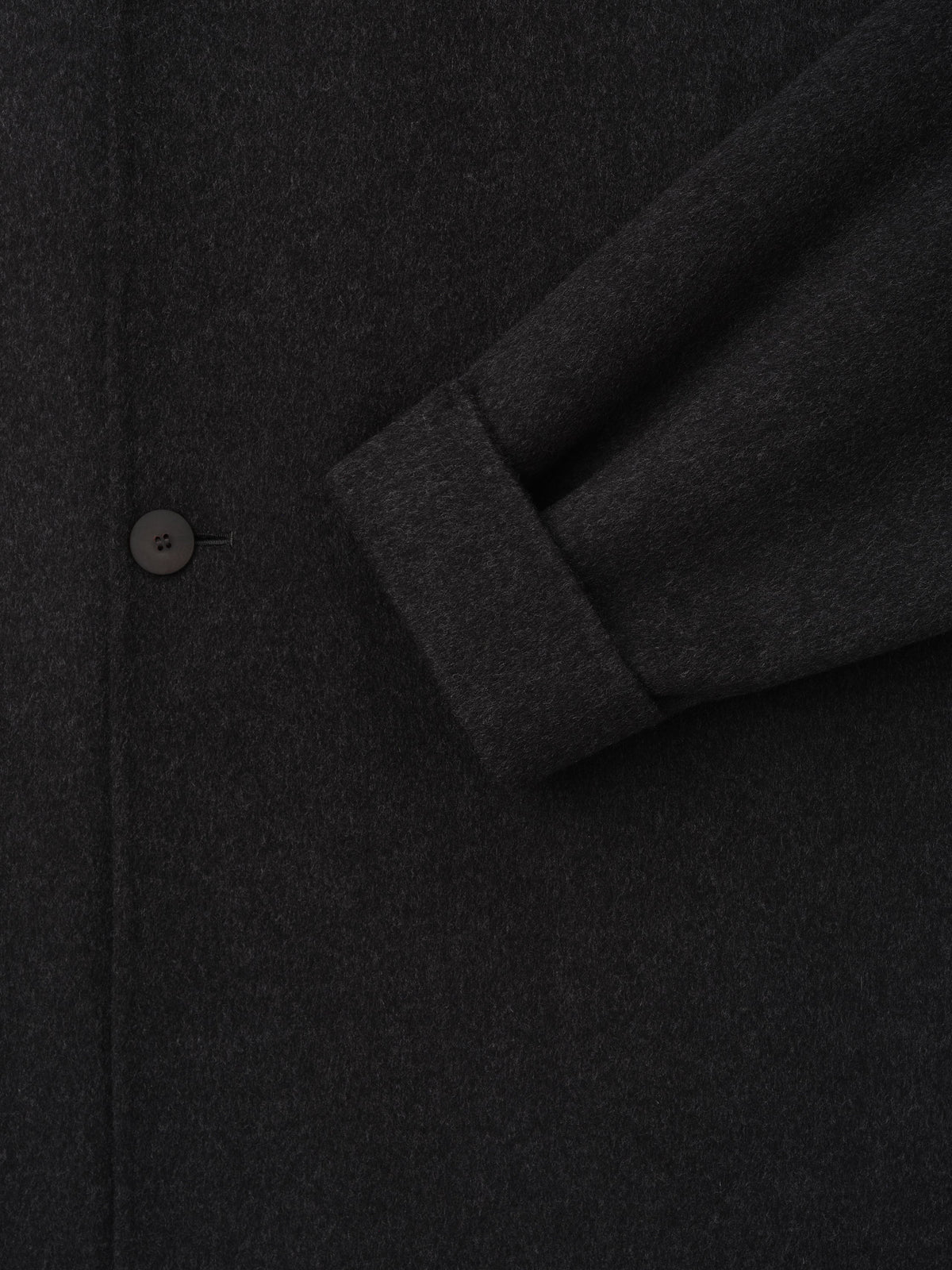 Double Face Wool Cashmere Overcoat in black shown in close detail with a sleeve cuff and button highlighting the soft textured fabric as Outerwear