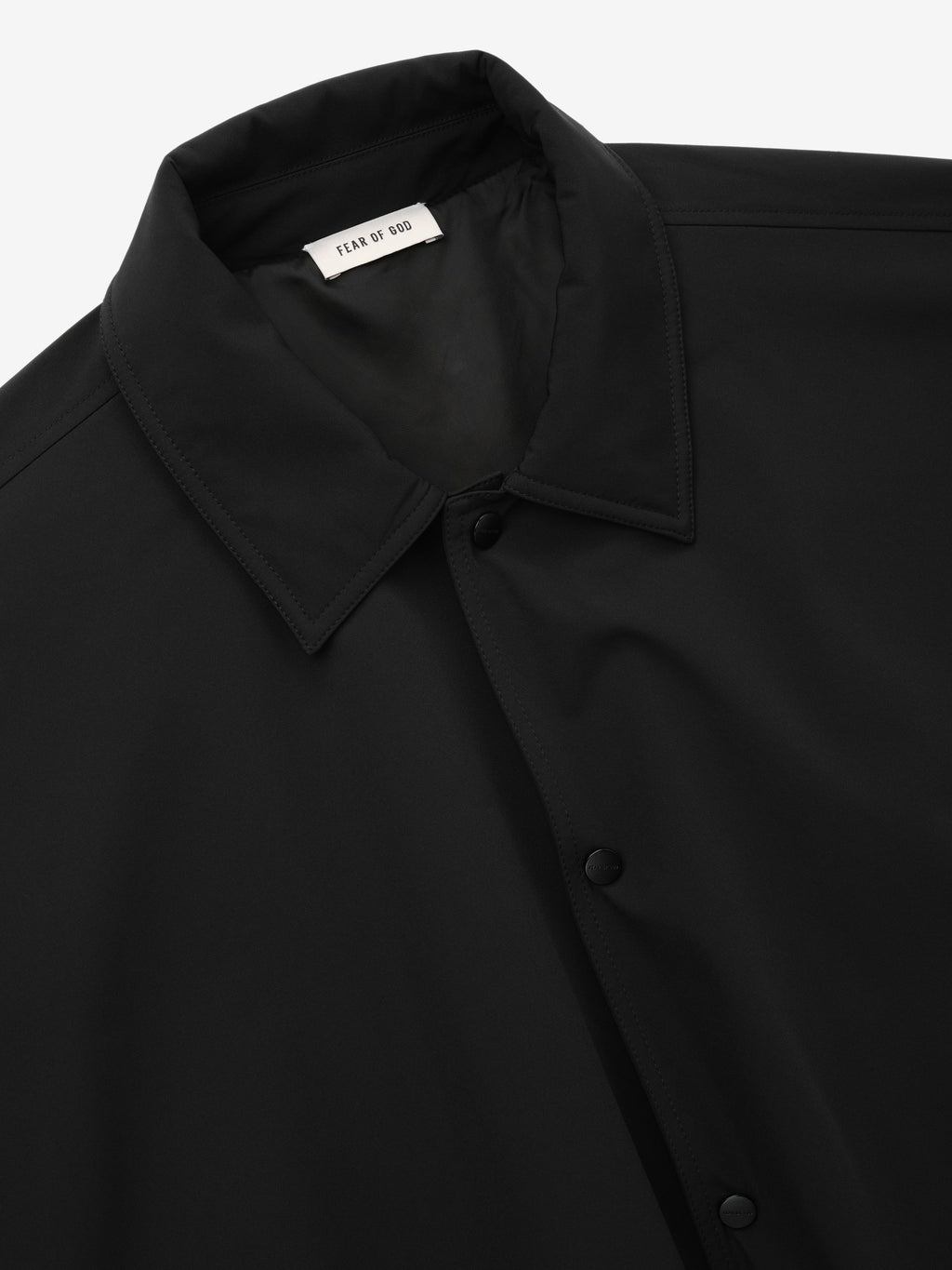 Bonded Nylon Tech Windbreaker in black shown in close detail with a shirt collar snap button front and Fear of God label as Outerwear