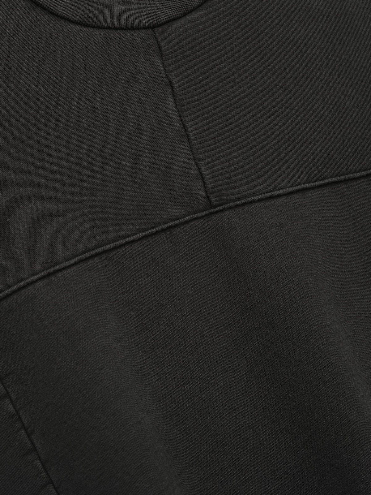 Heavy Fleece Crewneck in black shown in close detail with a ribbed neckline and paneled seam construction across the fleece body as Tops
