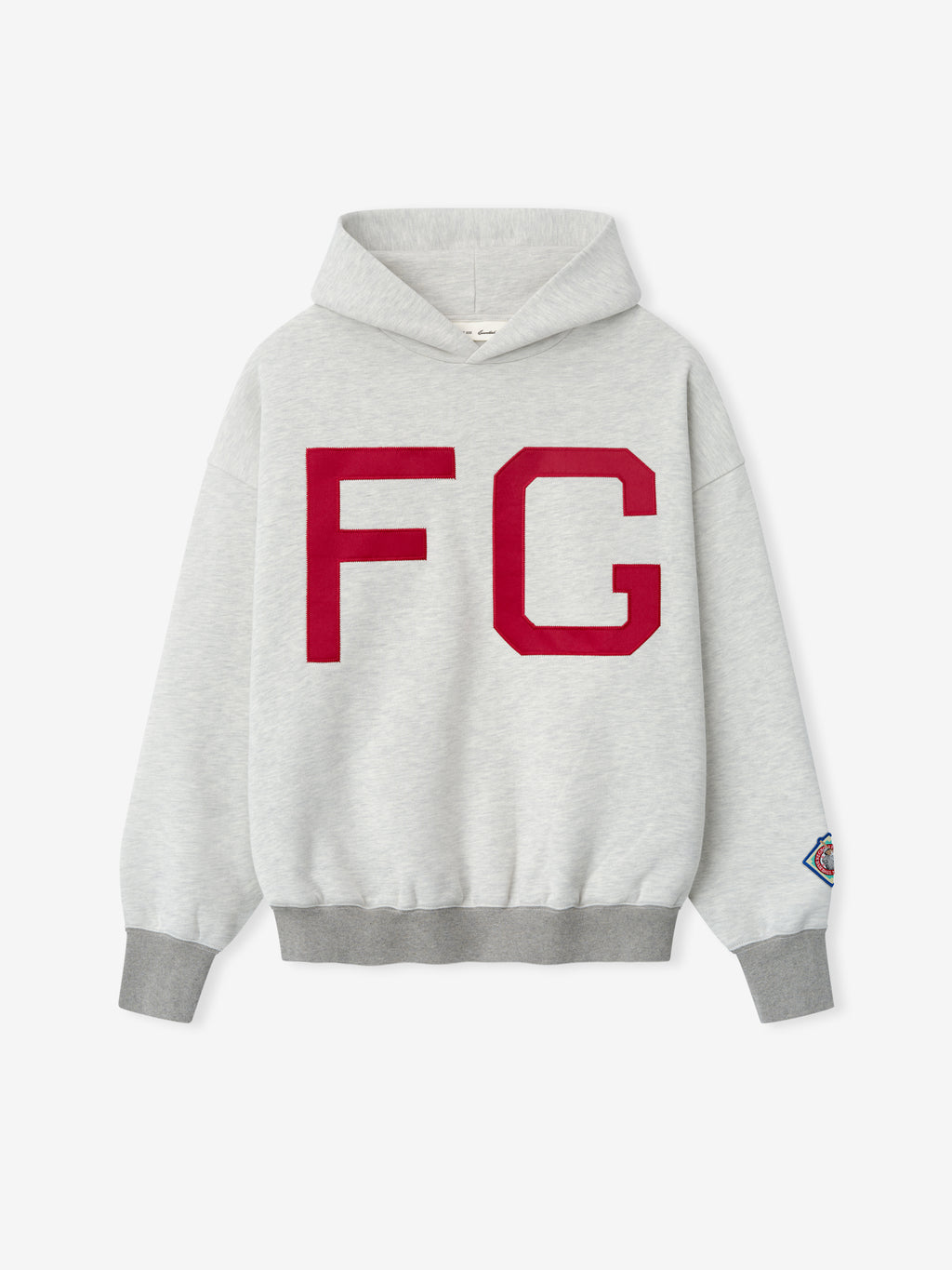 Light gray hoodie with large red FG letters on the front and a small colorful patch on the left sleeve cuff
