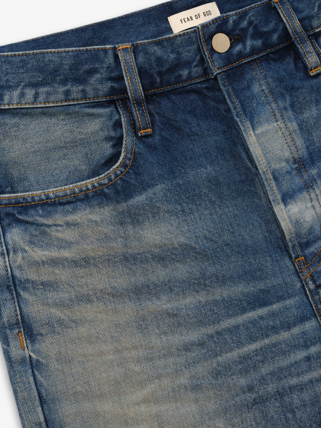 Flared Jeans in faded blue denim shown in close detail with a front pocket metal button belt loops whiskering and Fear of God label as Bottoms