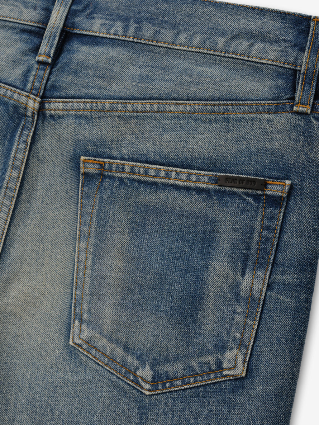 Flared Jeans in faded blue denim shown in close detail with a rear patch pocket belt loop tonal stitching and Fear of God label as Bottoms