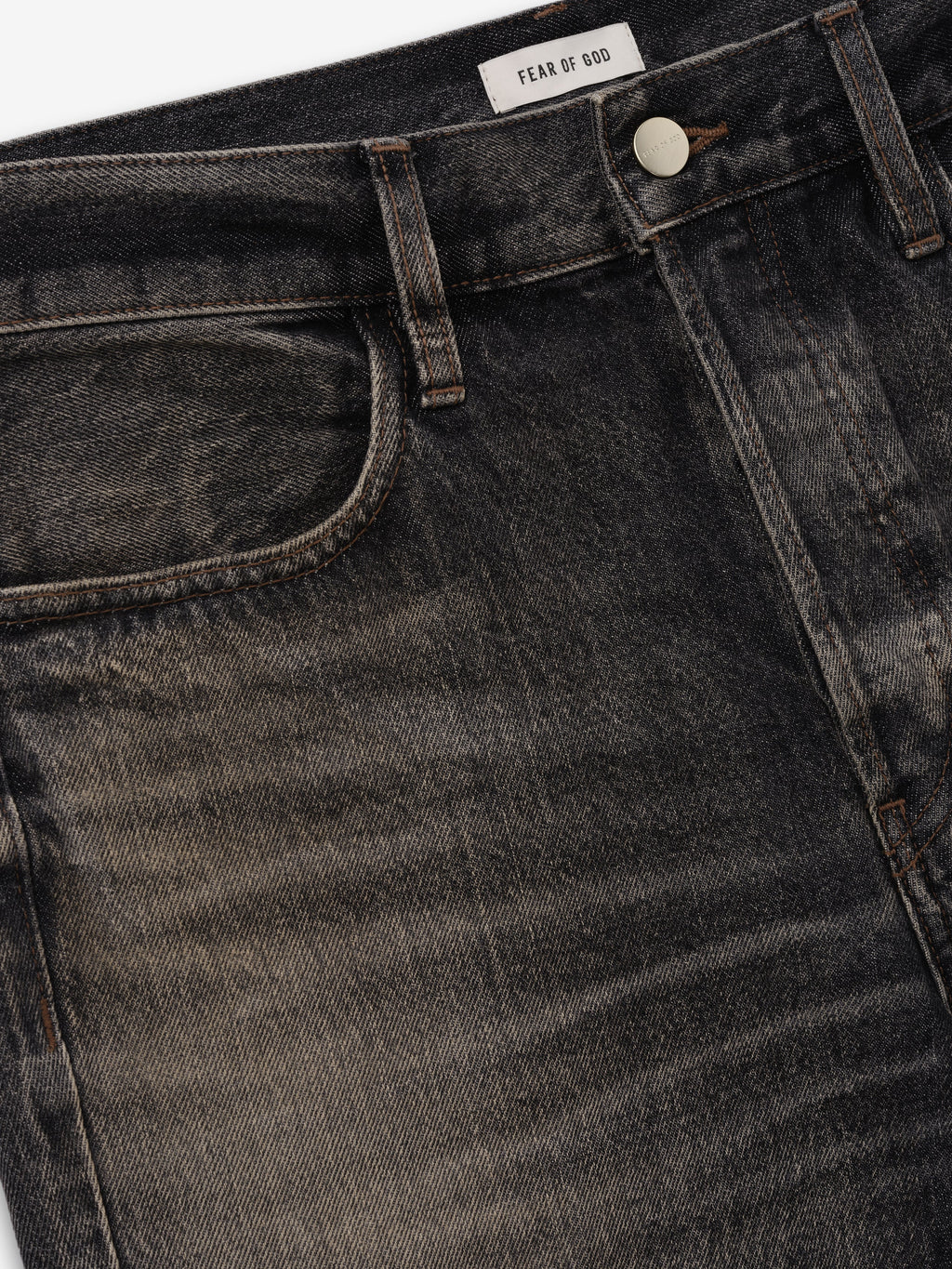 Flared Jeans in washed charcoal denim close detail showing a front pocket metal button belt loop whiskering and Fear of God label as Bottoms