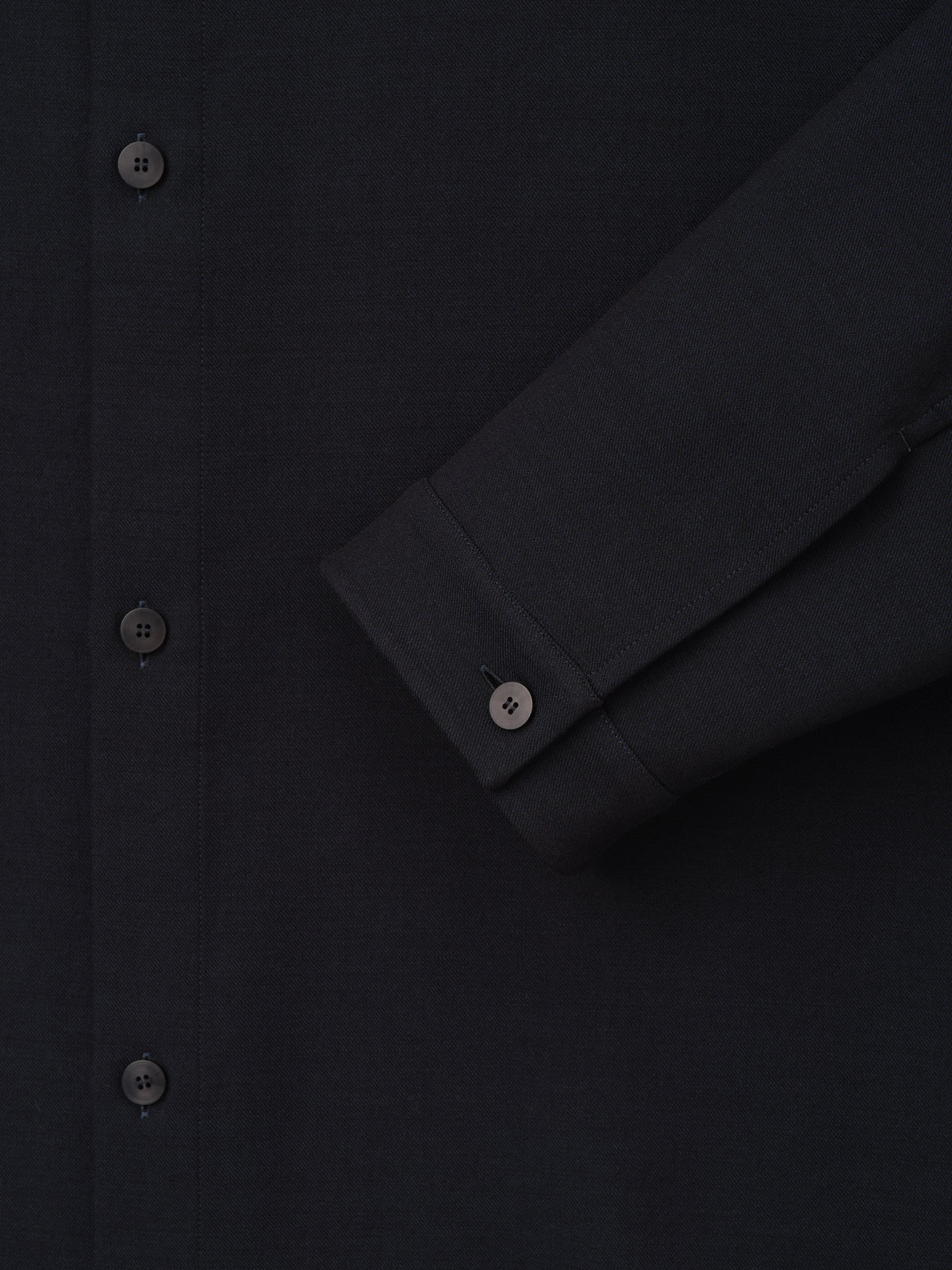 Double Weave Cotton Wool Overshirt shown close up in black with tonal buttons button front and cuffed sleeve as Tops
